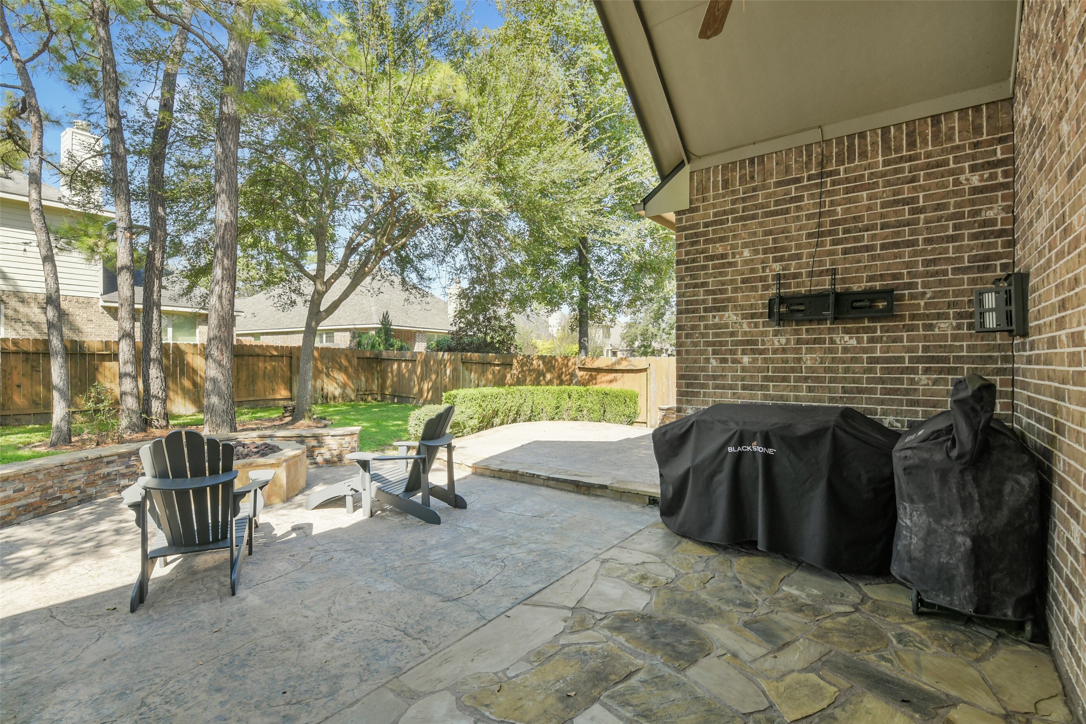Covered outdoor living area with brick fireplace, providing a wonderful setting for year-round entertaining.