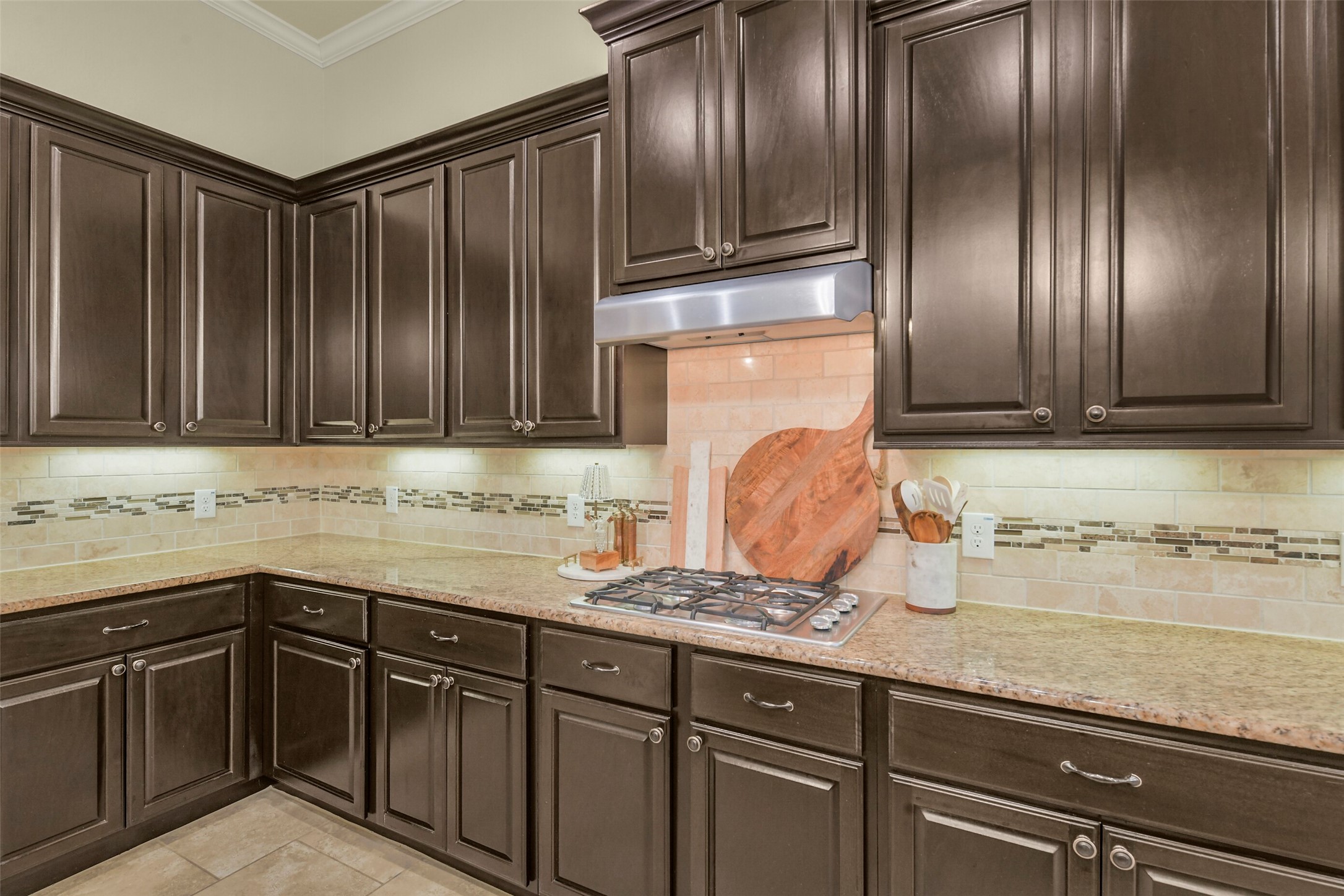 Beautiful wood cabinetry, tile backsplash, and generous preparation space create a functional kitchen.
