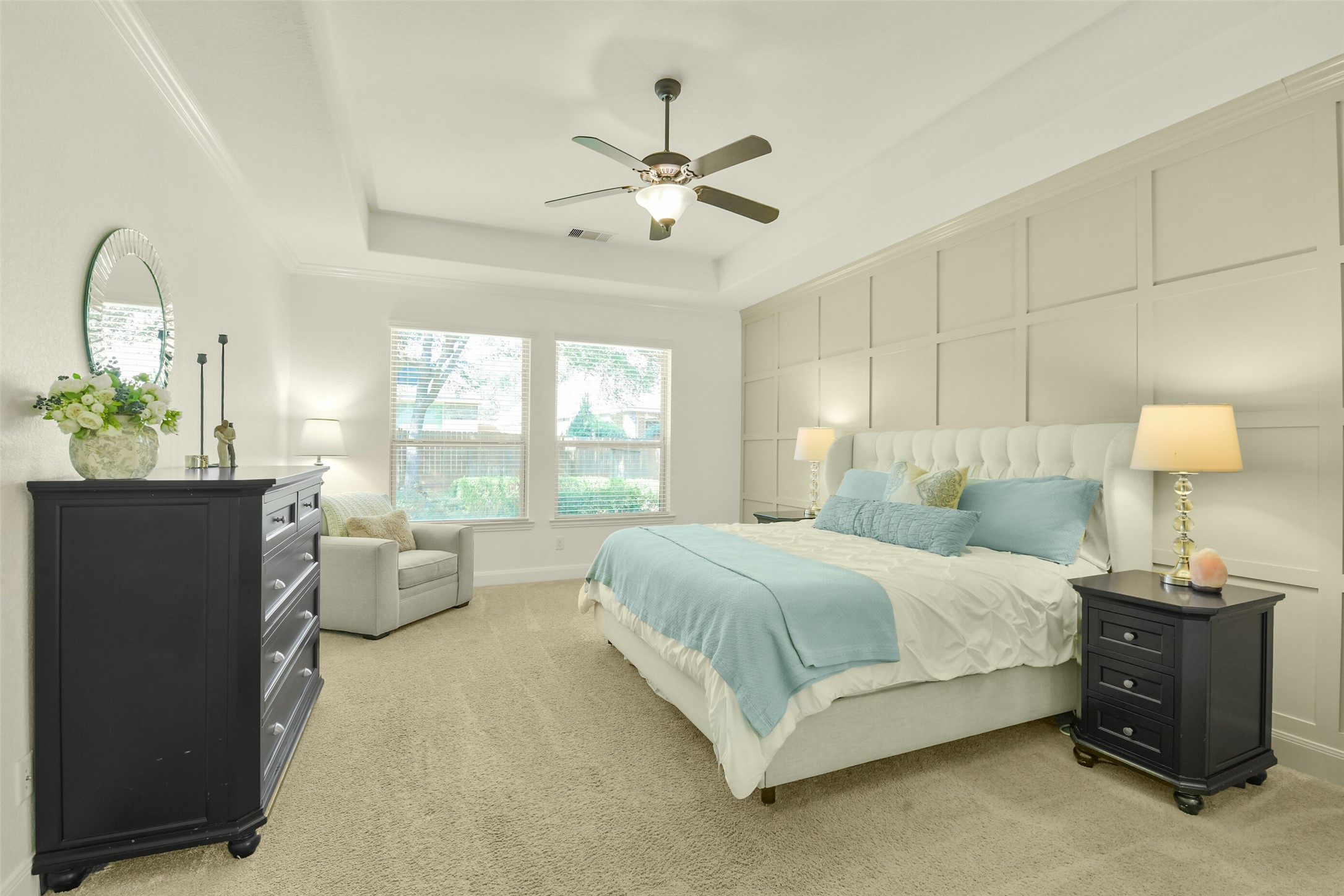 Spacious bedroom featuring neutral finishes, ceiling fan, and abundant natural light.