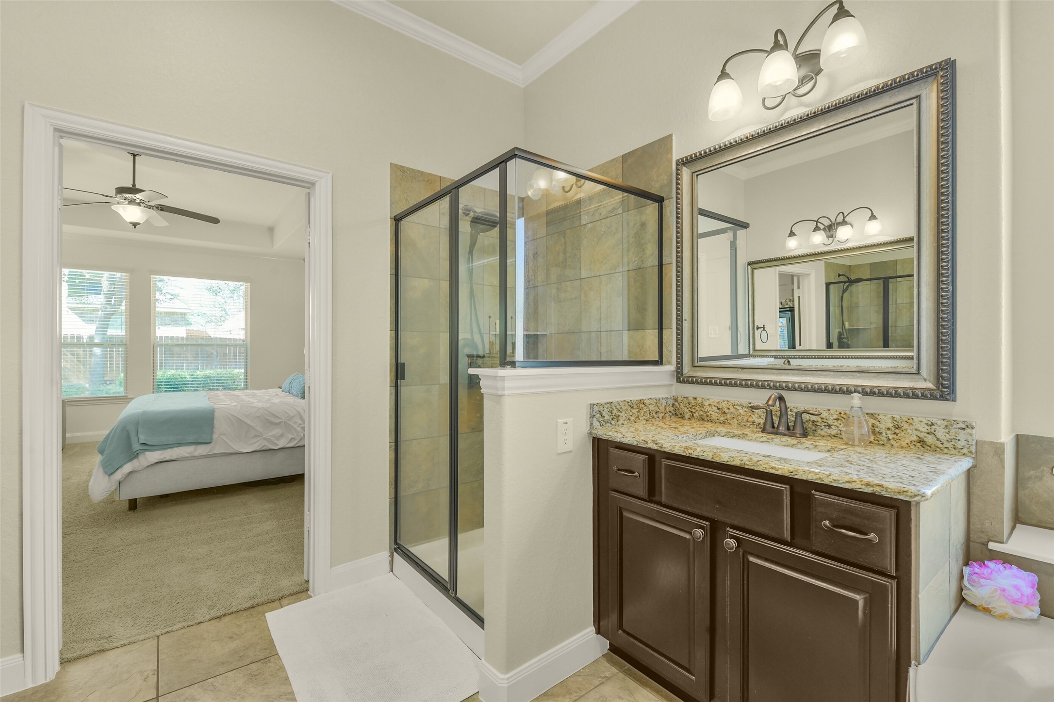 Primary bathroom featuring a glass-enclosed shower, double vanity, and elegant finishes.