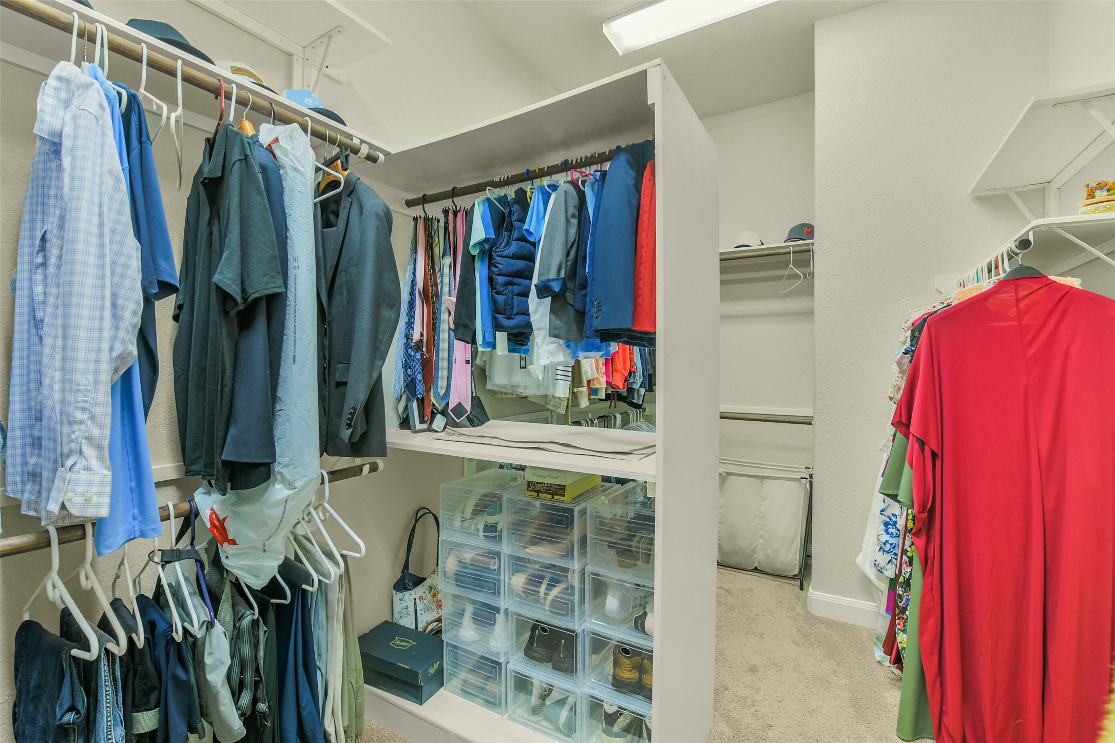 Spacious walk-in closet with built-in shelving and abundant hanging storage.