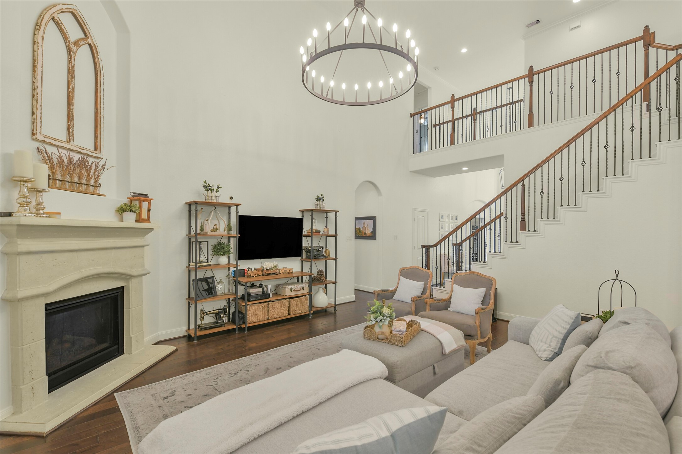 Open-concept living room showcasing the fireplace, staircase, and beautiful architectural details.