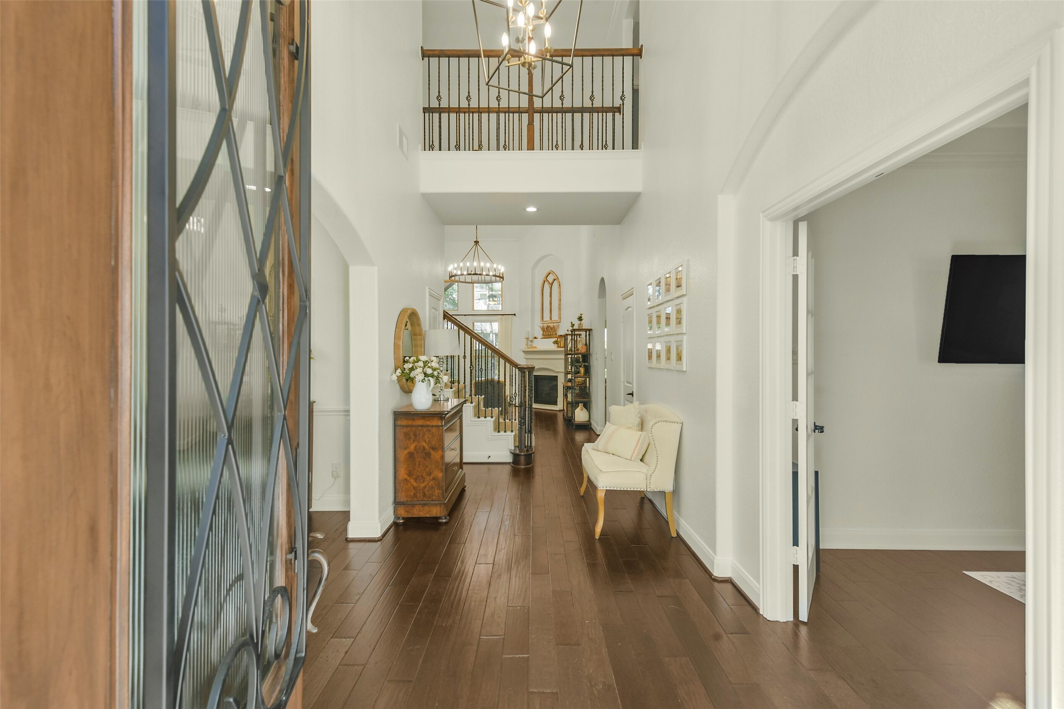 Elegant entryway featuring rich wood flooring, soaring ceilings, and a view into the home's open living spaces.