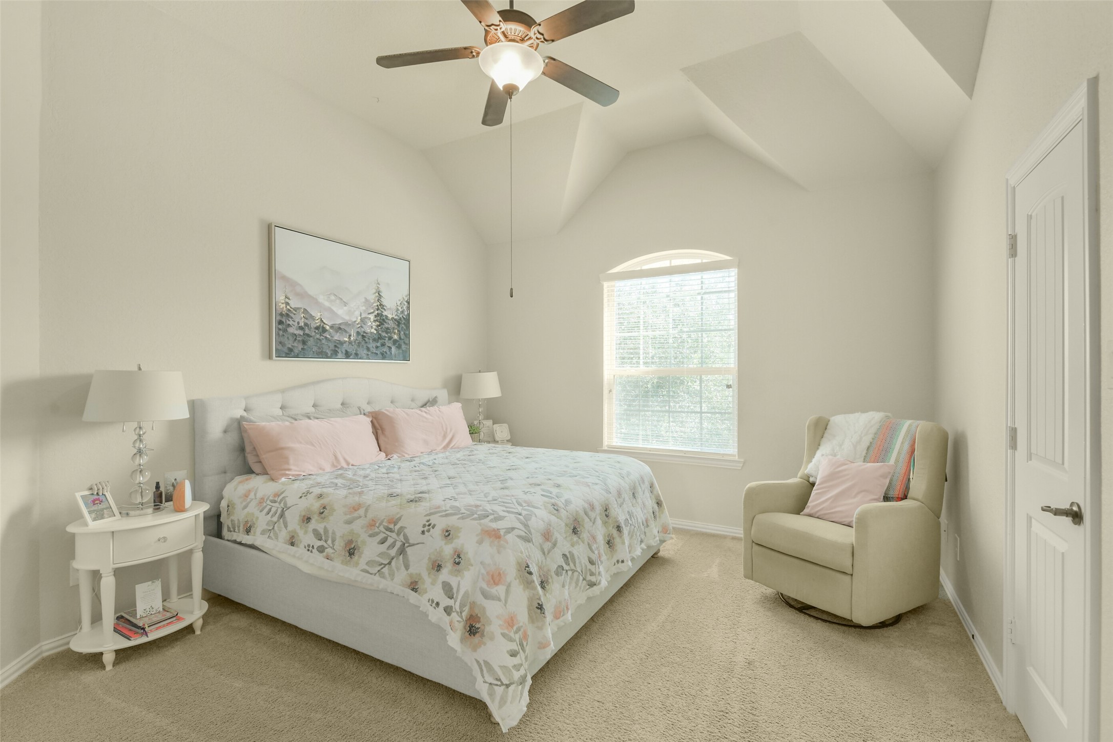 Charming secondary bedroom with vaulted ceiling, natural light, and comfortable proportions.