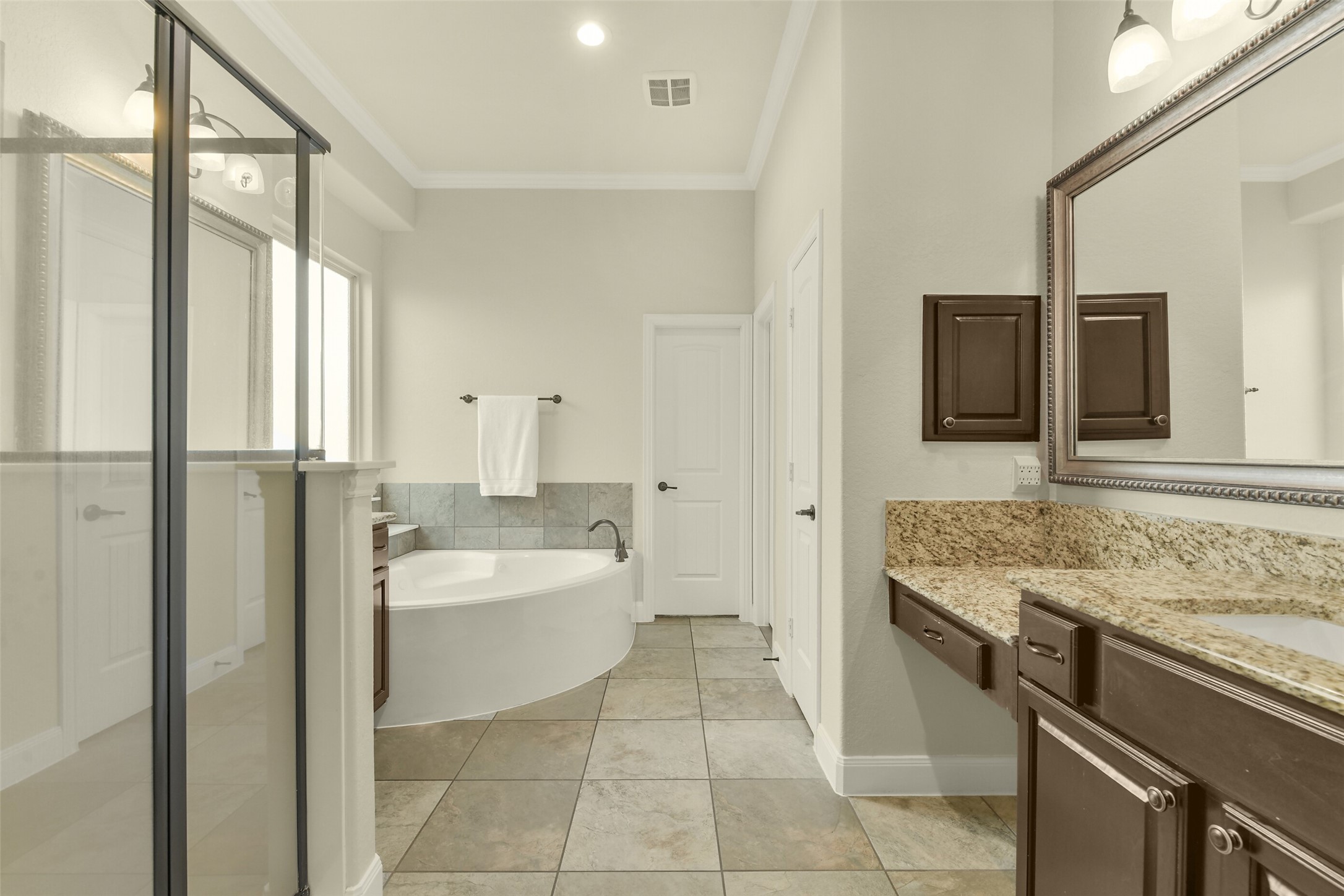Primary bathroom with separate shower, expansive vanity, and spacious layout.