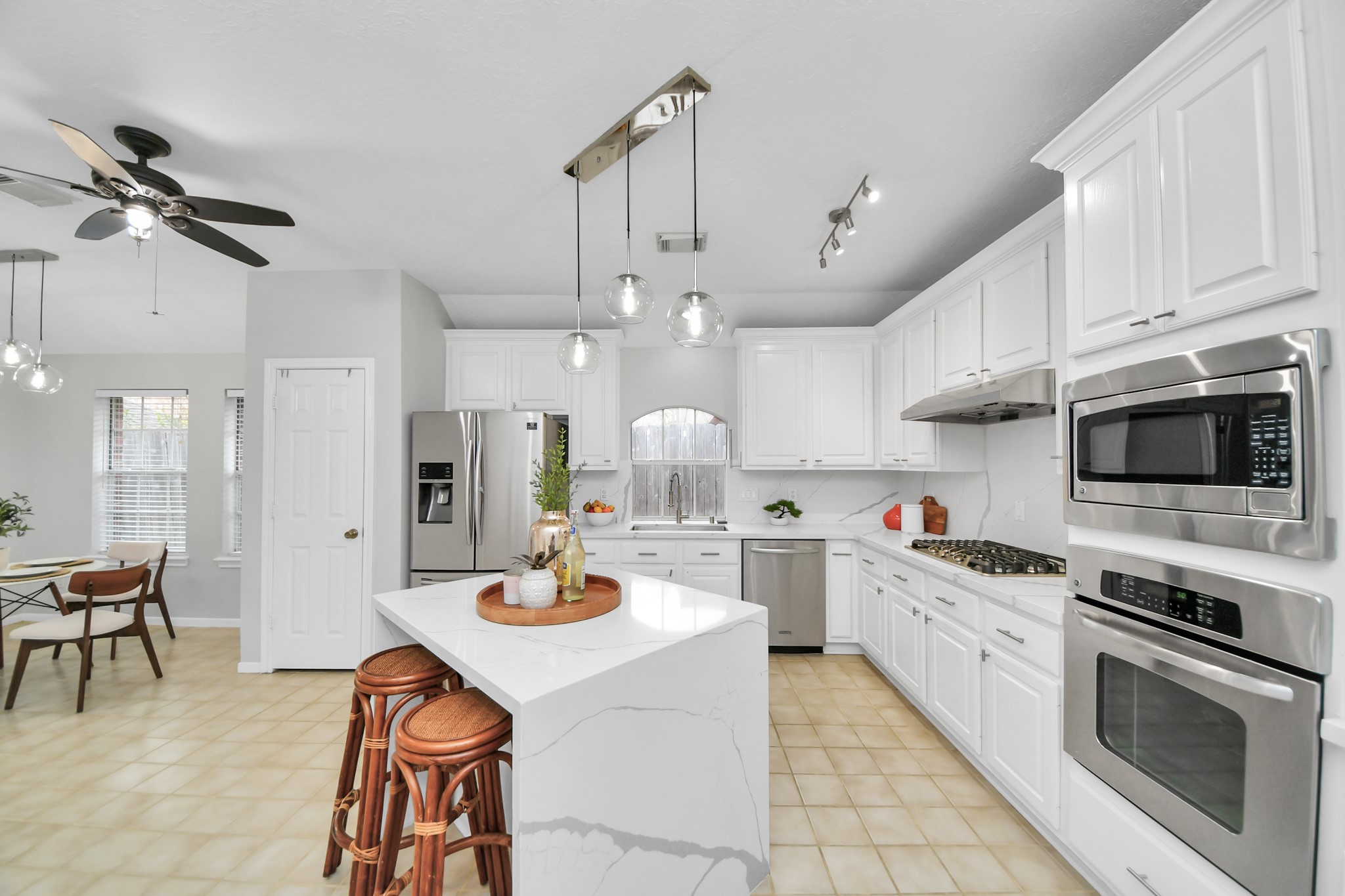 Another view of the kitchen showing the gas cooktop, built-in oven and microwave, and plenty of cabinet space. The island offers extra room for meal prep and seating.