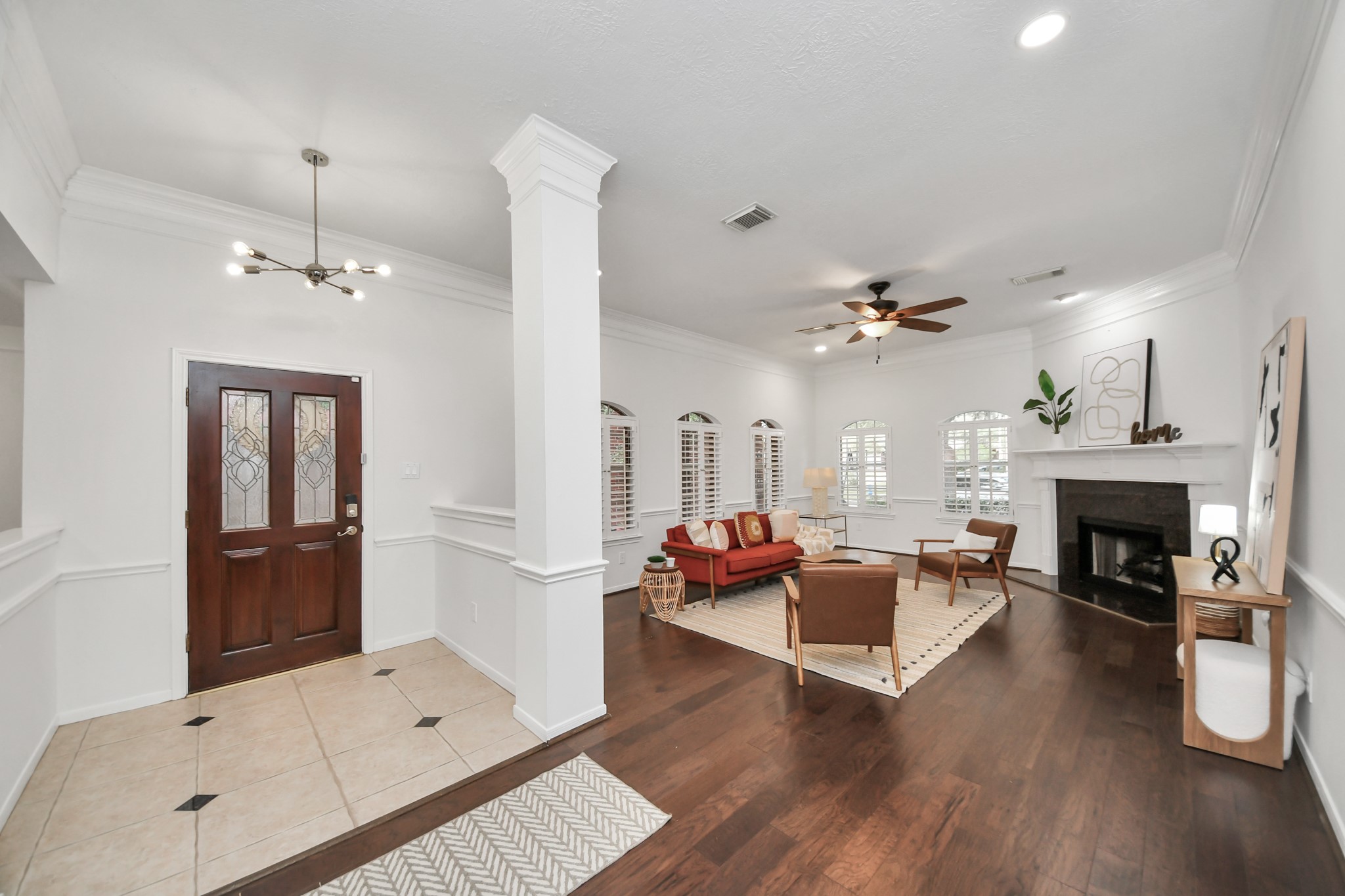 The living room has plenty of natural light, plantation shutters, and a fireplace. A comfortable space to relax or spend time with guests.