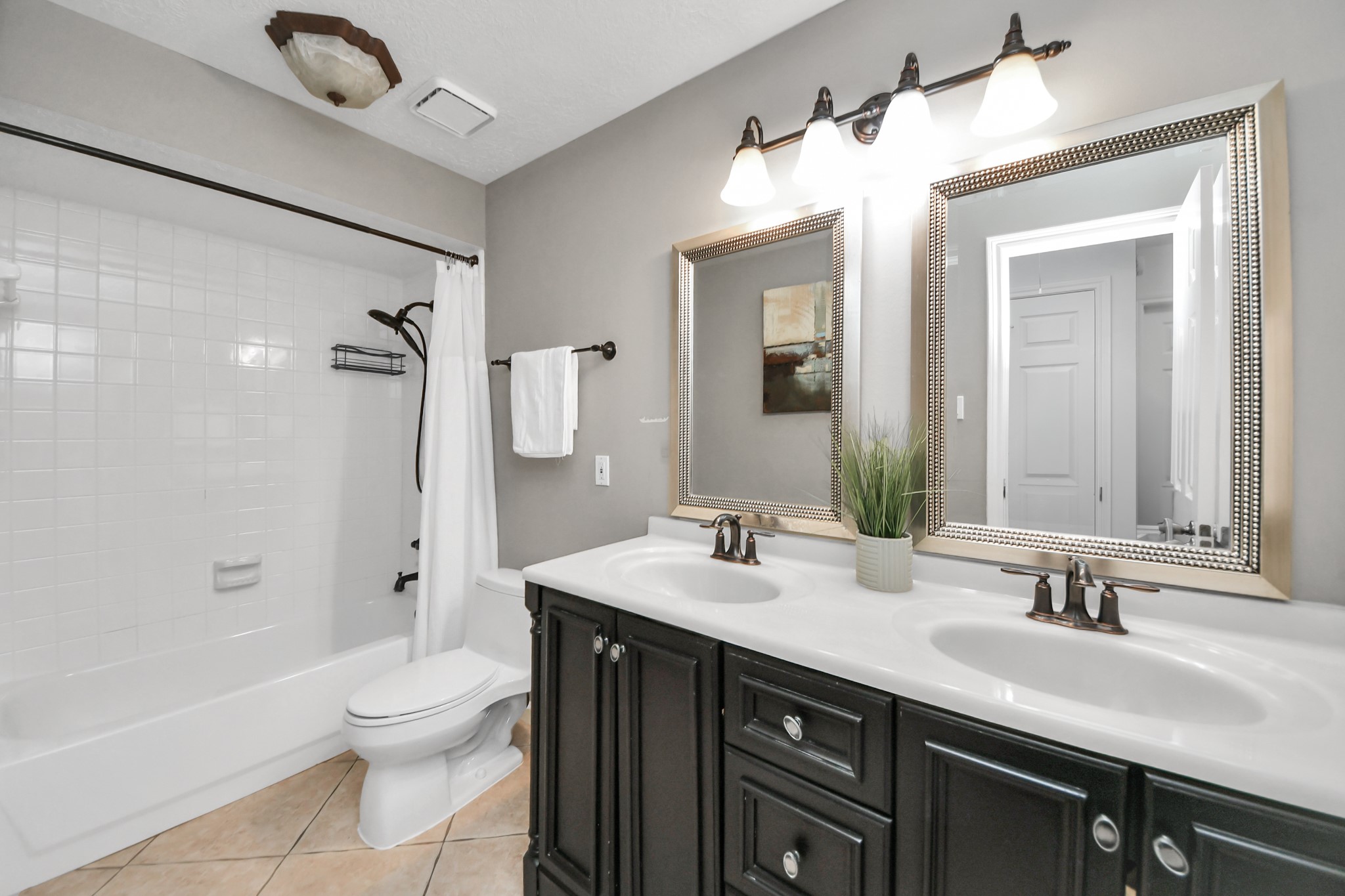 The secondary bathroom features two sinks, plenty of cabinet storage, and a tub and shower combination.