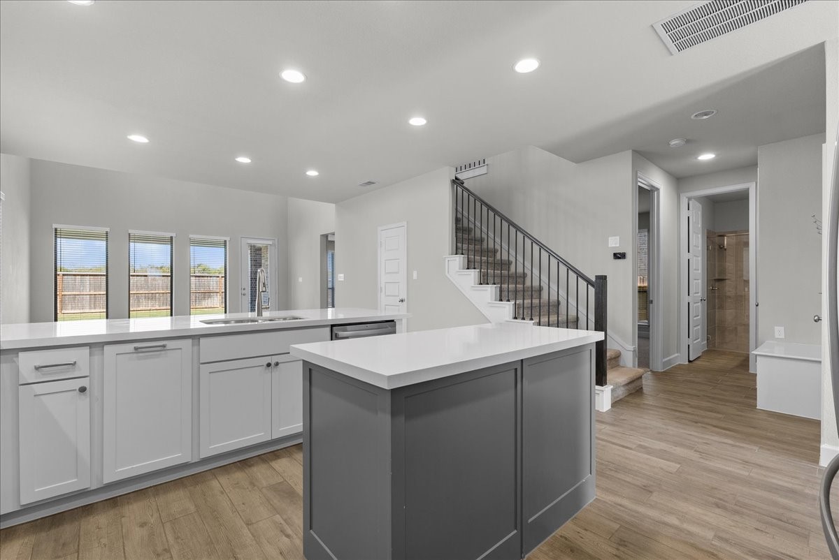 View of the kitchen and on the right of the stairs is the guest bedroom/bathroom downstairs.