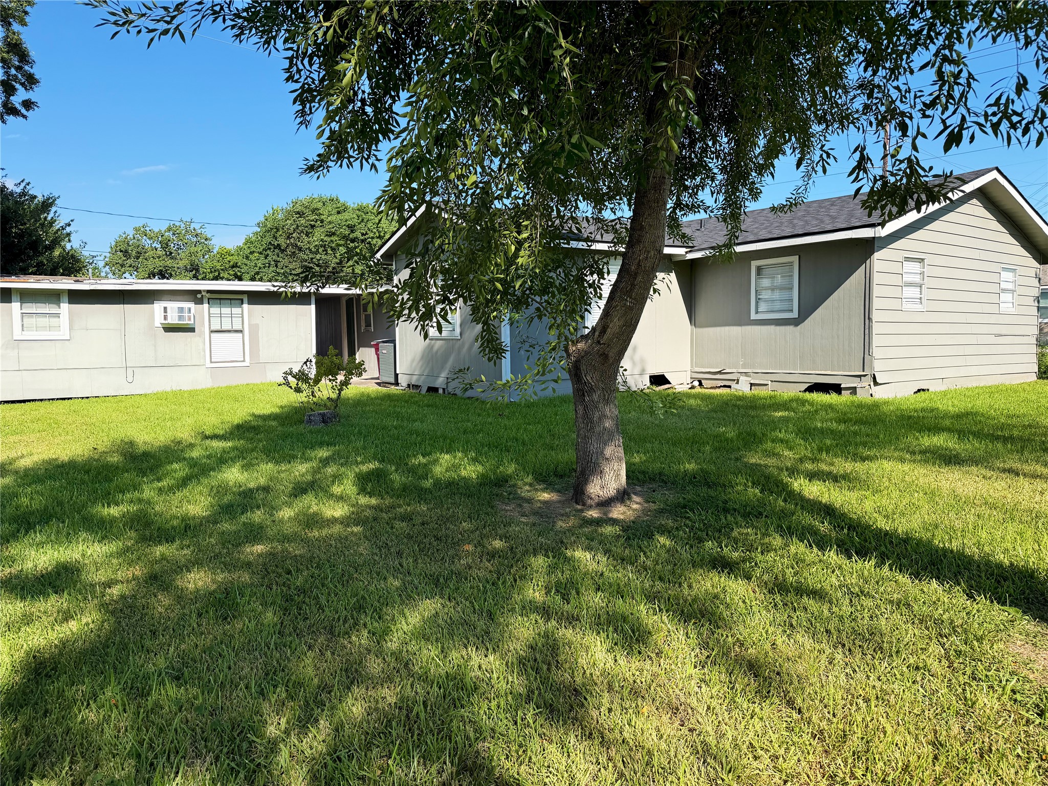 Spacious backyard with plenty of room for outdoor activities, complemented by mature trees that provide natural shade.