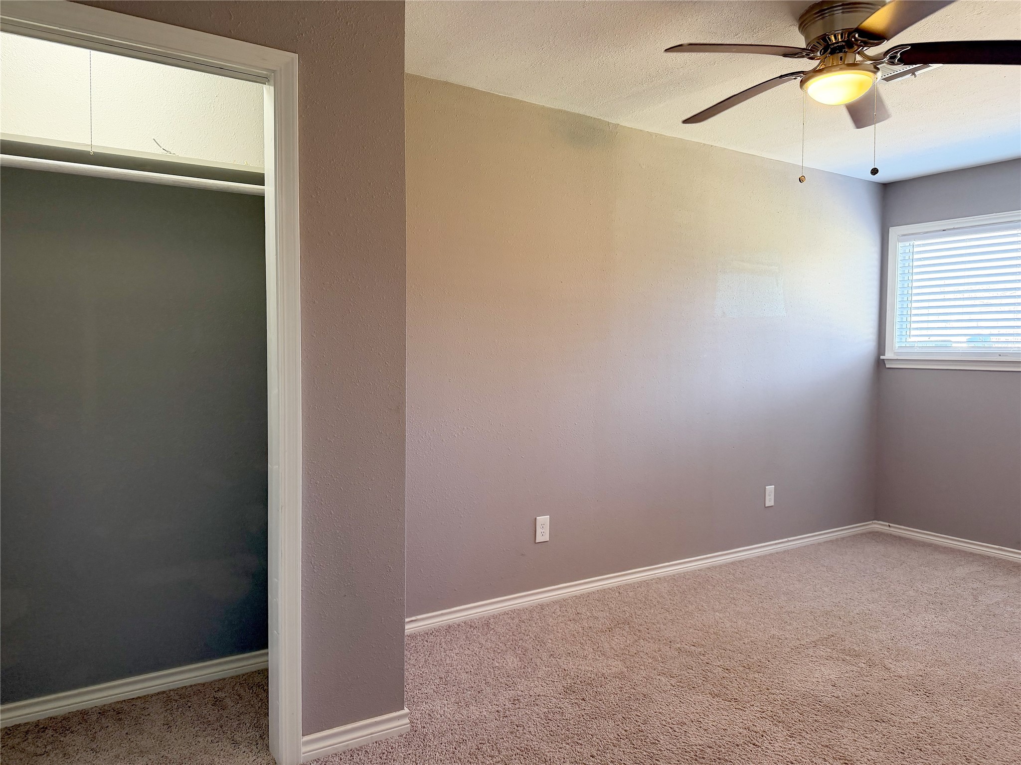 Carpeted secondary bedroom provides a functional layout with room for bedroom furnishings and storage.