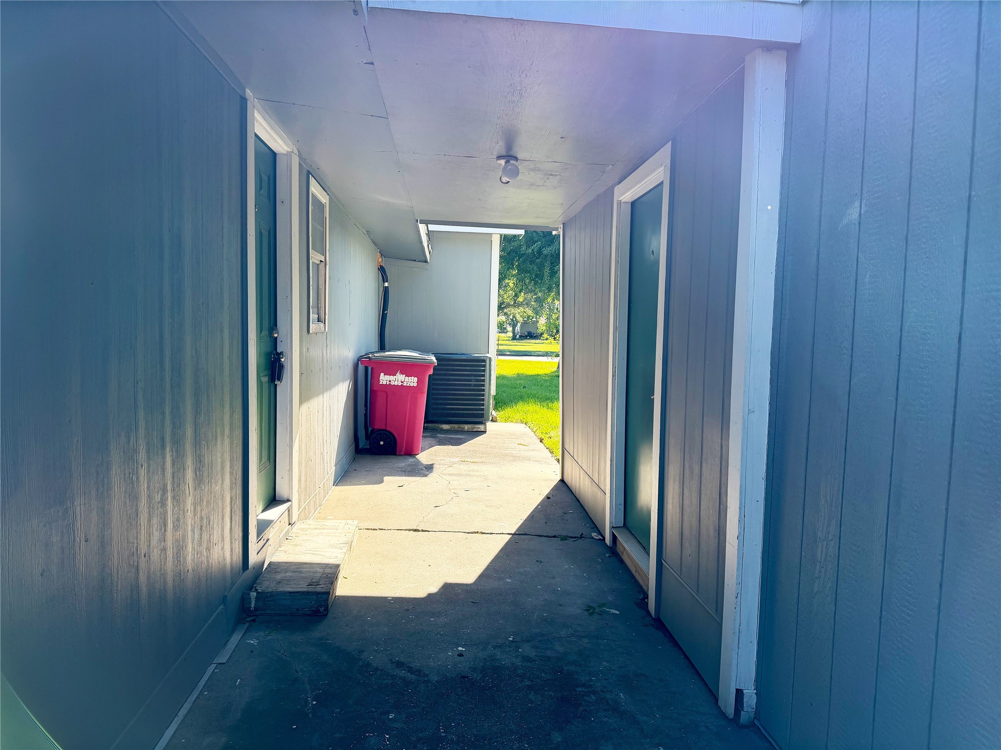 Covered walkway connects the back door to the separate garage apartment, providing a sheltered path between the two spaces.
