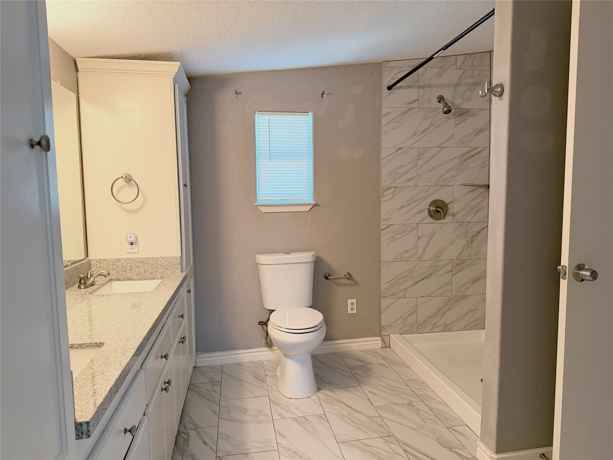 Primary bathroom features a stand-up shower, double sinks, and a functional layout with space for everyday storage and use. Primary bathroom features a stand-up shower, double sinks, and a functional layout with space for everyday storage and use.