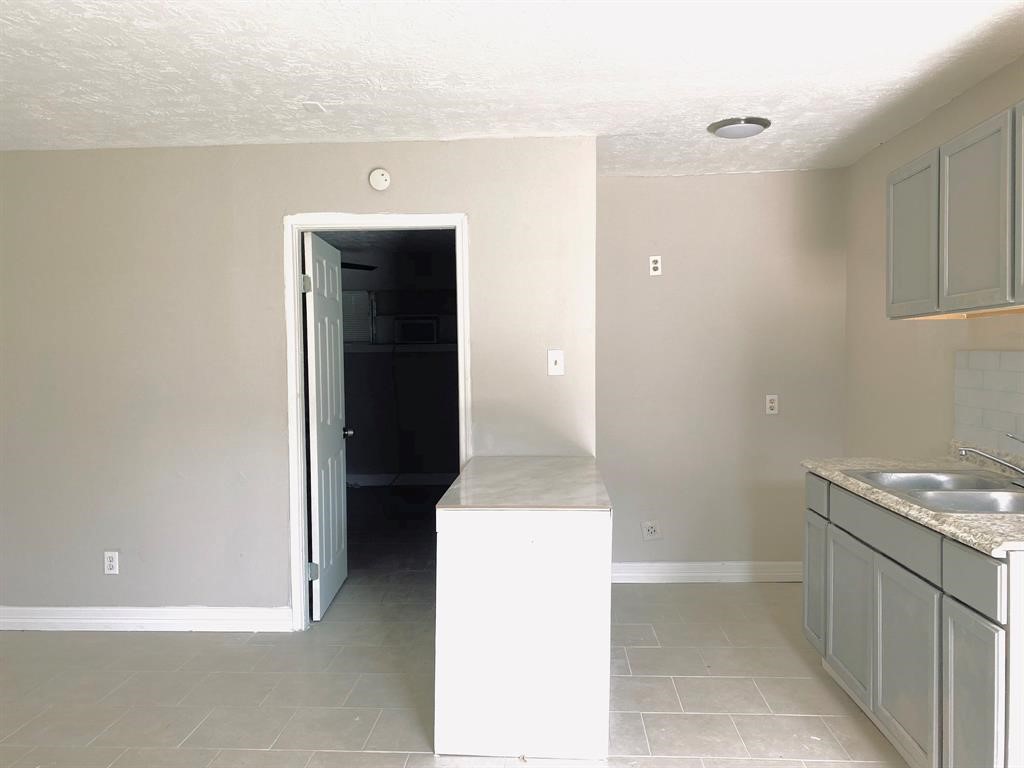 Bright kitchen featuring light gray cabinetry, modern countertops, and a convenient dual sink.
