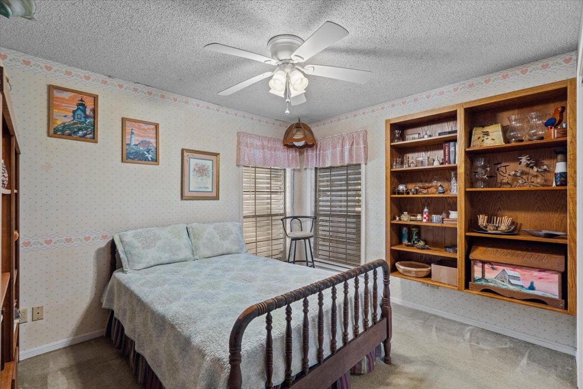 Third bedroom with carpet and shelving.