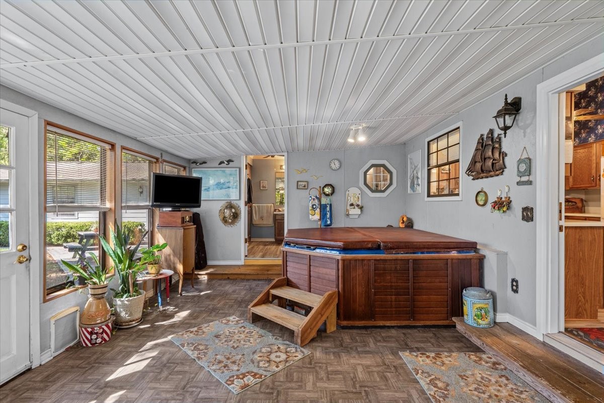 Screened in patio with hot tub and door to bathroom.
