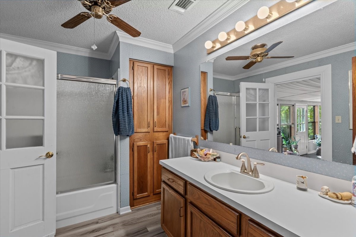Secondary bedroom with tub/shower combo and door to screened in patio.