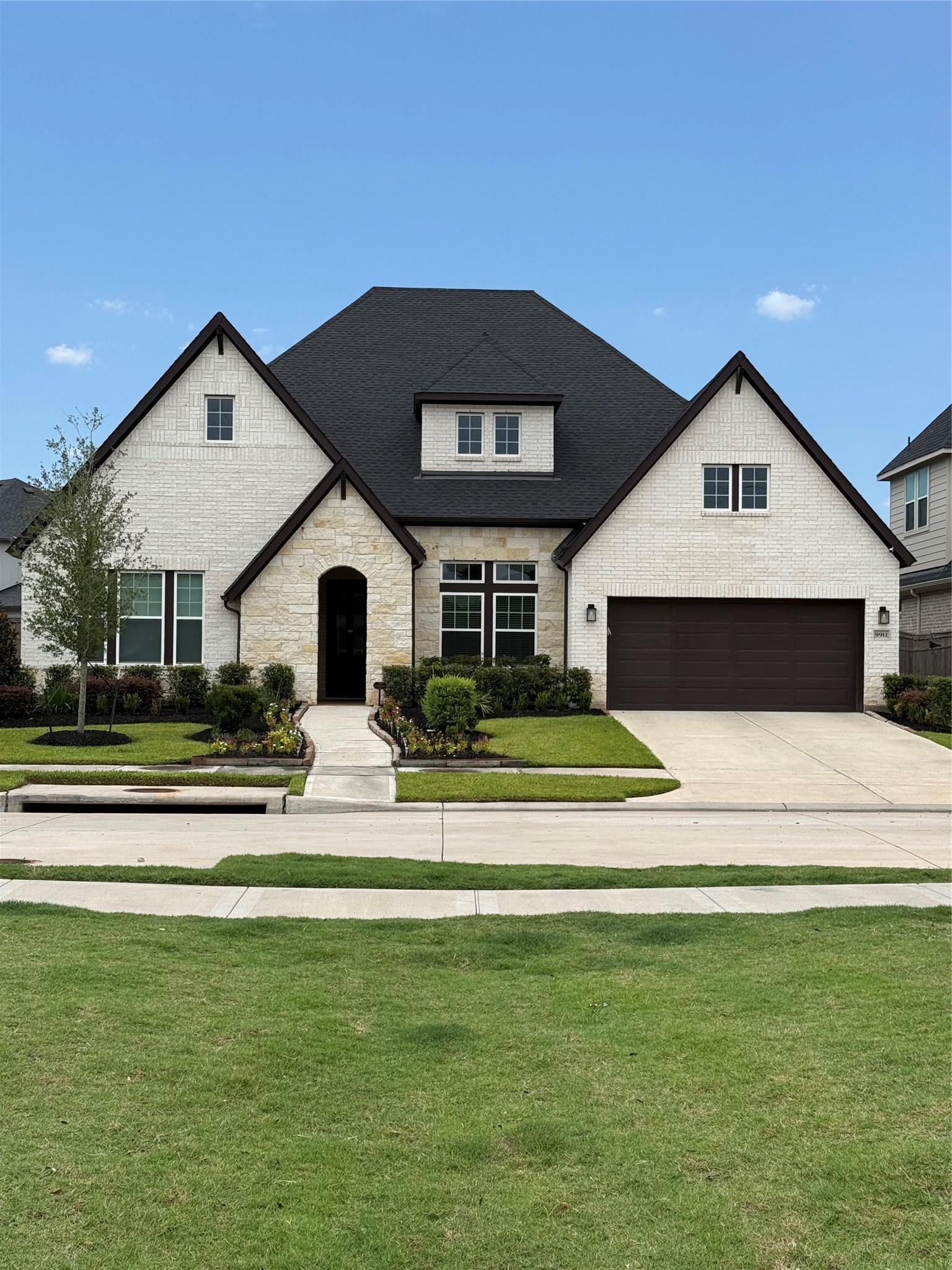 Charming one story home disguised as a 2 story, with a striking dark roof and light brick exterior, featuring a spacious 4-car garage and manicured front lawn. Charming one story home disguised as a 2 story, with a striking dark roof and light brick exterior, featuring a spacious 4-car garage and manicured front lawn.