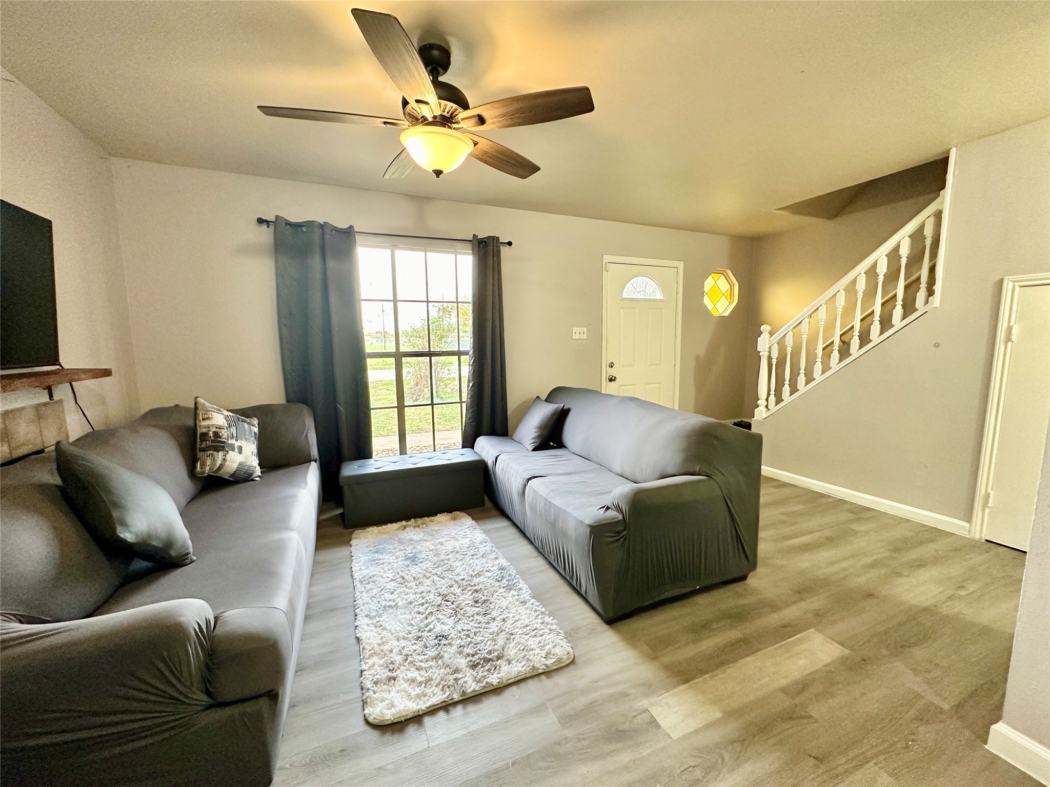 Charming living room features lighted ceiling fan, wood vinyl plank flooring and wood burning fireplace. Charming living room features lighted ceiling fan, wood vinyl plank flooring and wood burning fireplace.