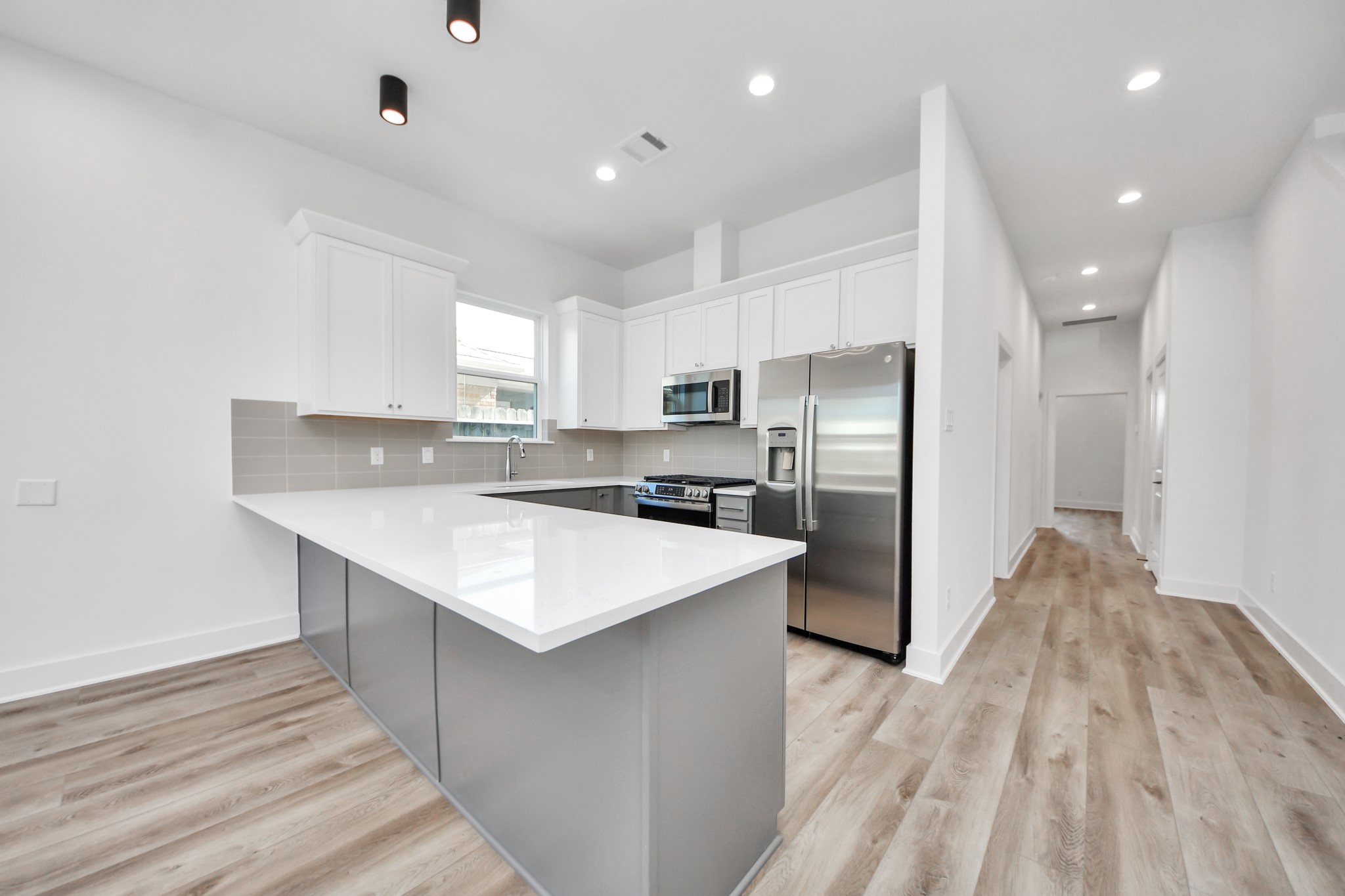 Unit B kitchen with a spacious island and quartz countertops.
