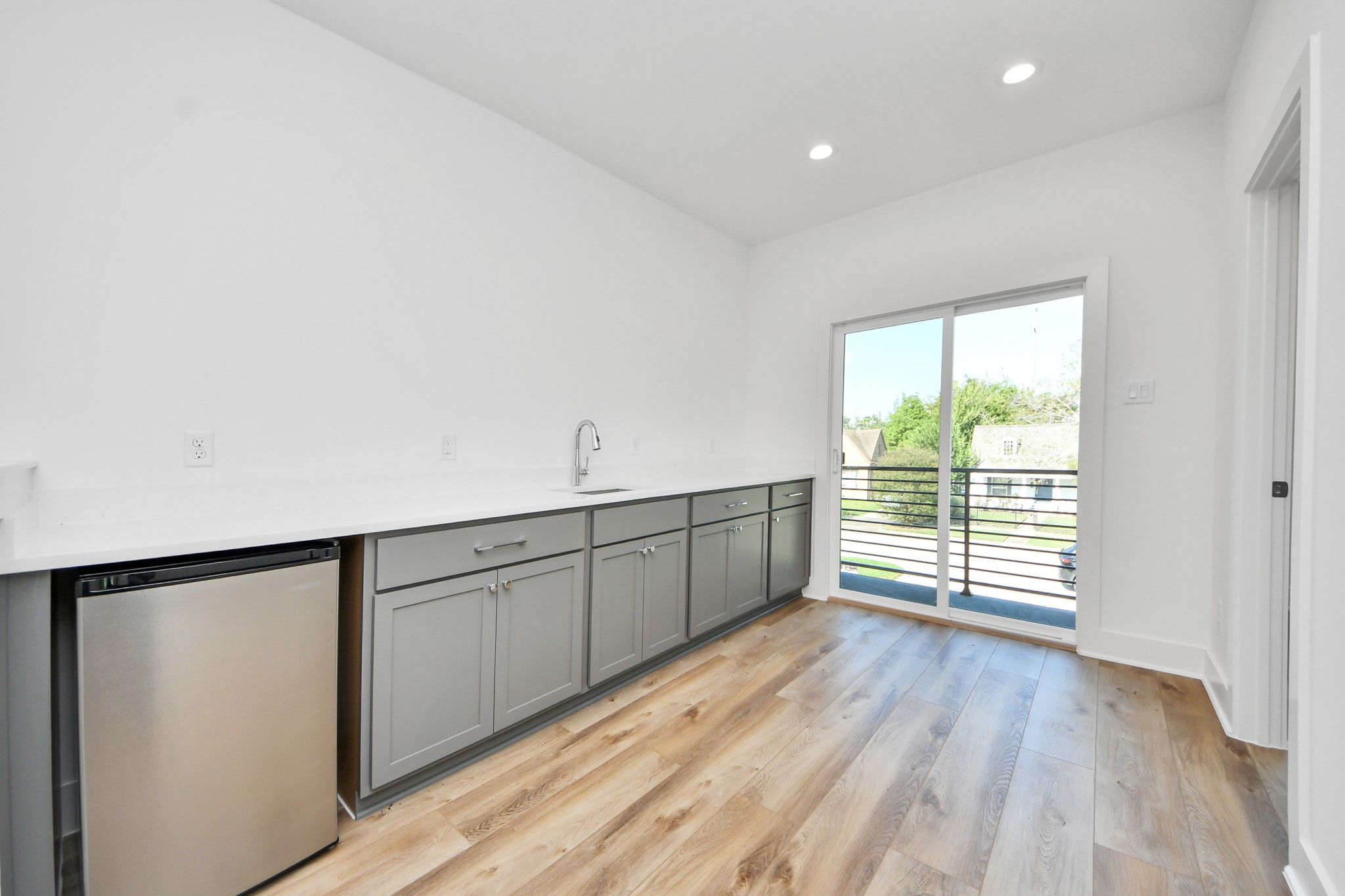 Unit B upstairs wet bar with countertop space, sink, and beverage refrigerator.
