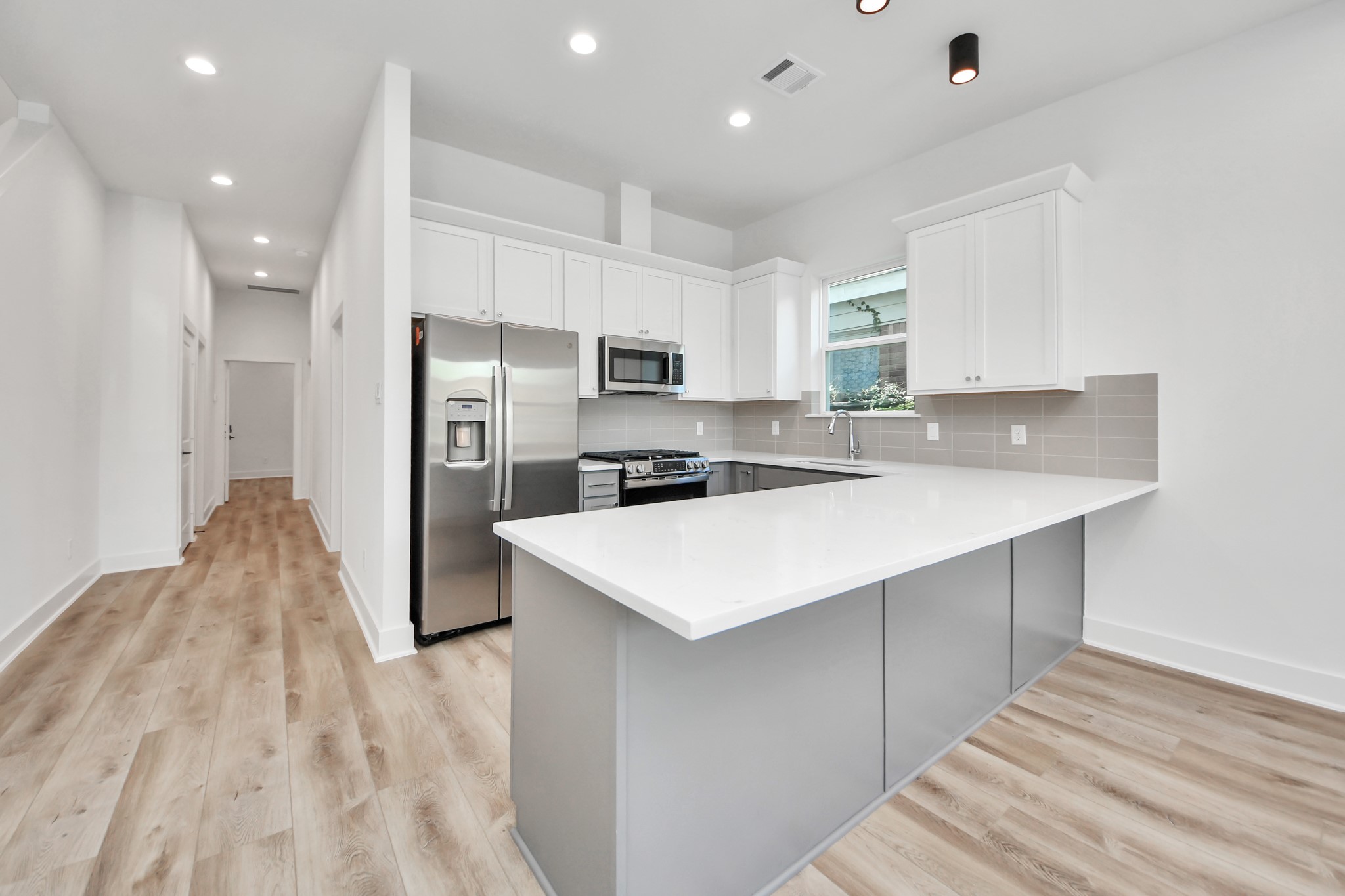 Unit A kitchen with a spacious island and quartz countertops. Unit A kitchen with a spacious island and quartz countertops.
