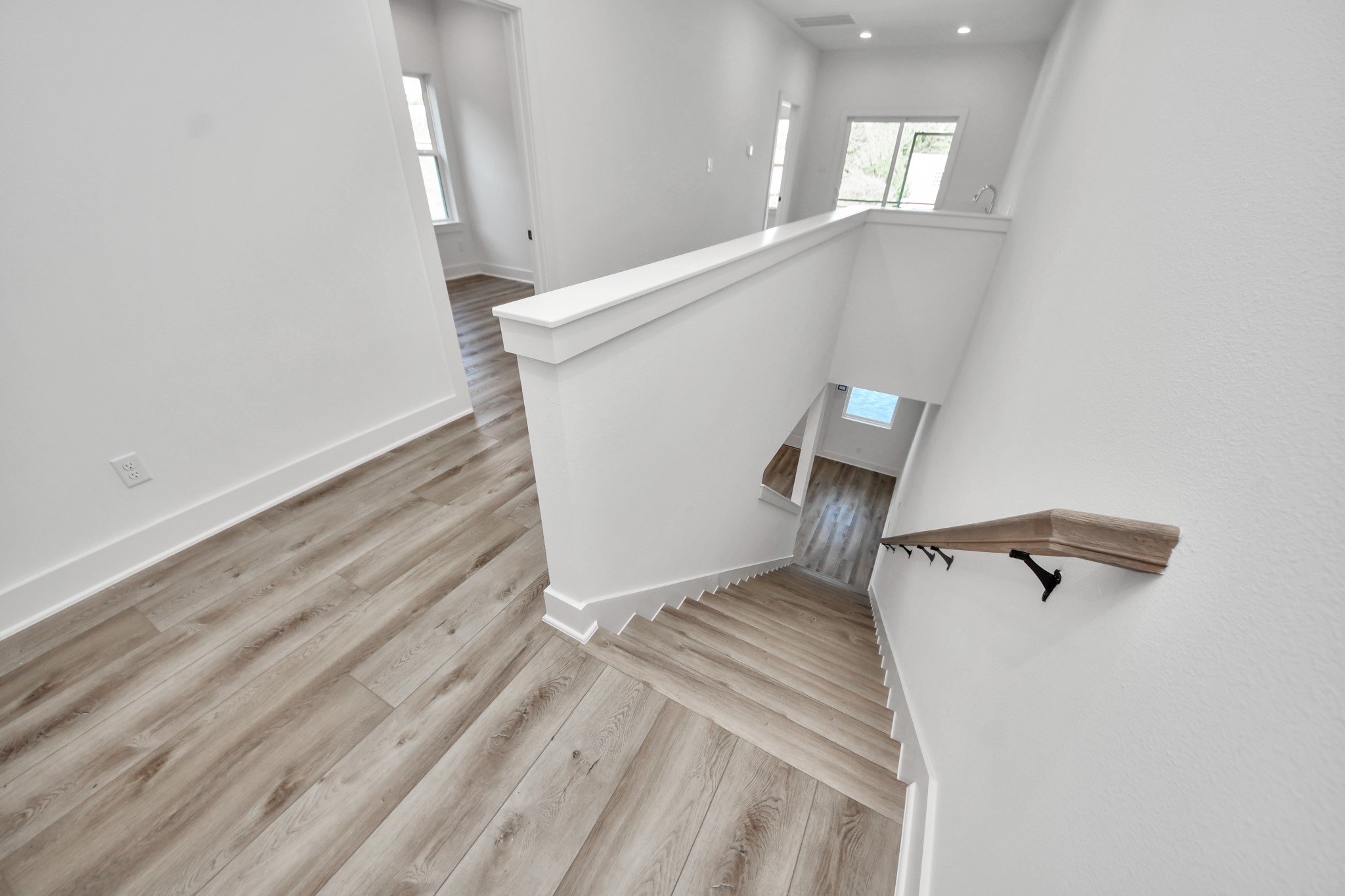 Unit A upstairs landing with wood-look flooring and stairway access.