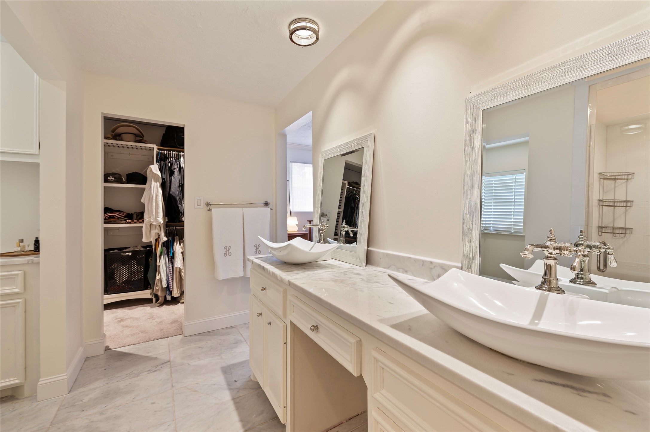 Beautifully updated primary bath with his/her sinks, vanity mirrors and walk in closet. Tile flooring throughout.