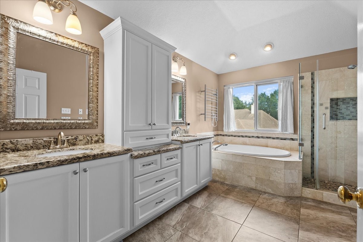 Check out the dual sinks, soaking tub, frameless and shower.