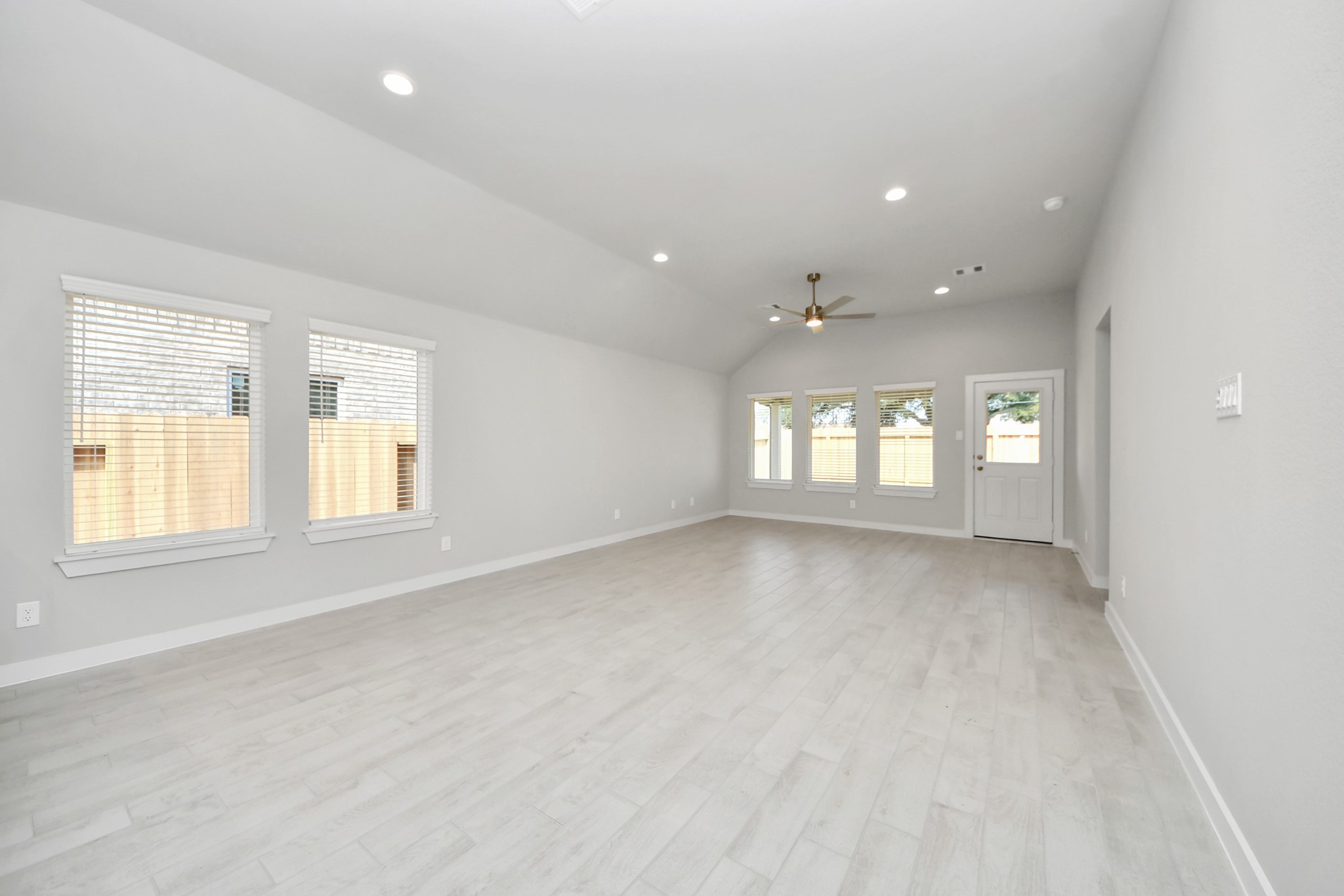 Relax and unwind in this inviting family room, illuminated by abundant natural light streaming in through tall windows, complemented by high ceilings and stunning flooring. Stay comfortable year-round with the gentle breeze from the ceiling fan, creating the perfect atmosphere for family gatherings. Sample photo of completed home with similar floor plan. Actual colors and selections may vary.