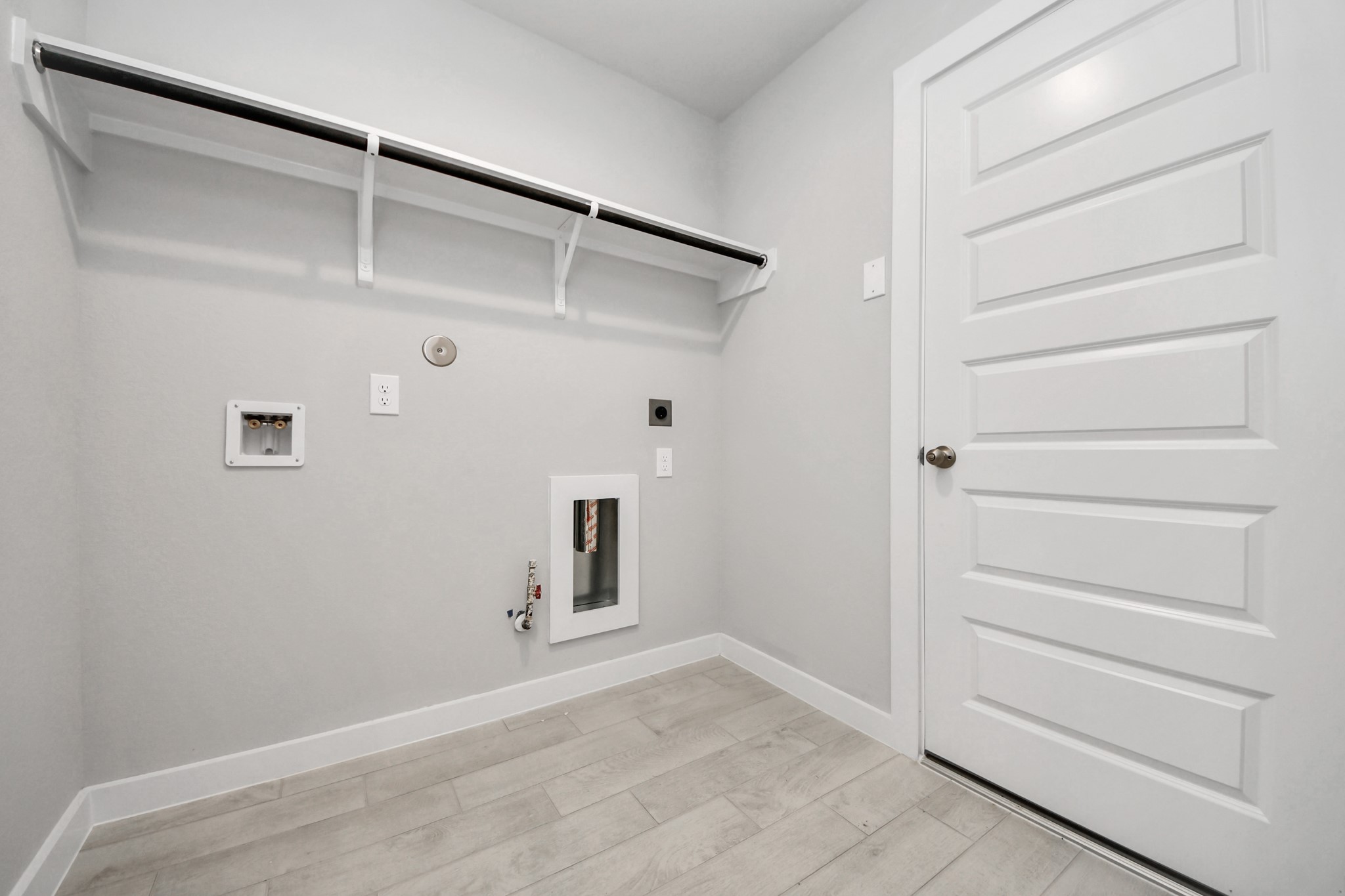 A perfect blend of functionality and comfort. Capture the essence of easy living with a first-floor laundry room, thoughtfully equipped with shelving for effortless organization. Both electric and gas connections available. Sample photo of completed home with similar floor plan. Actual colors and selections may vary.