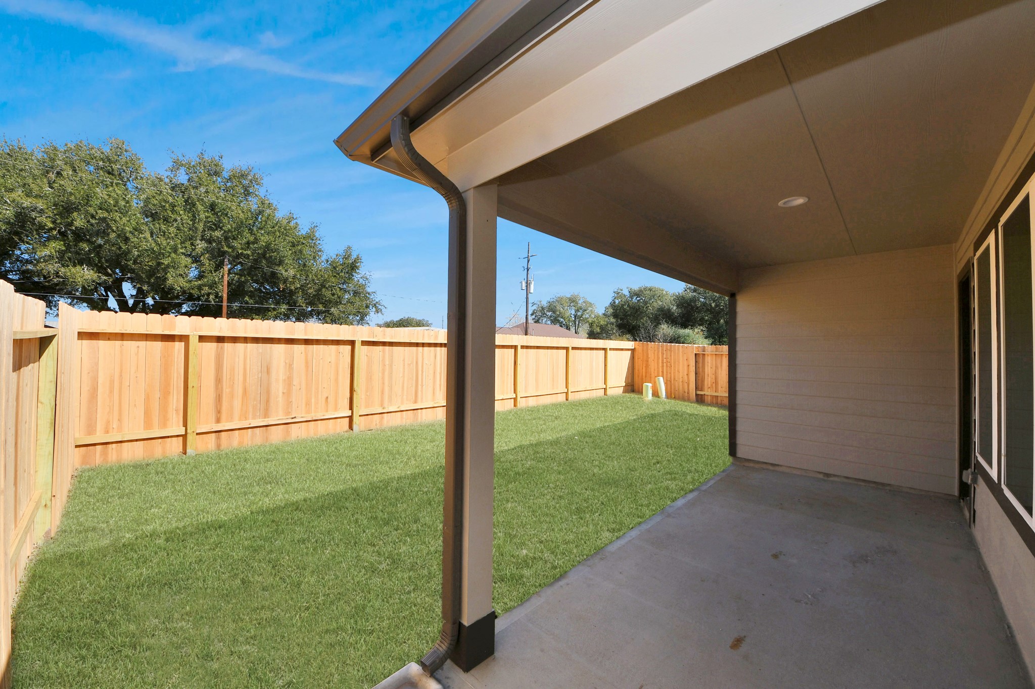Experience outdoor living at its finest on this expansive covered patio, thoughtfully designed for BBQs and delightful outdoor dining. Sample photo of completed home with similar floor plan. Actual colors and selections may vary.