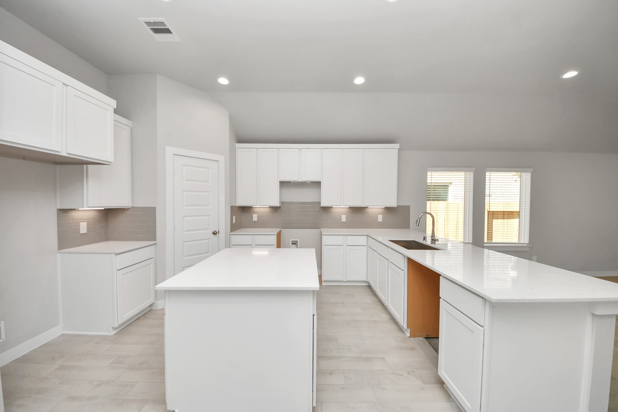 The kitchen is a culinary haven, featuring granite countertops, a tile backsplash, stainless steel appliances, 42 upper cabinets, and undercabinet lighting. Sample photo of completed home with similar floor plan. Actual colors and selections may vary.