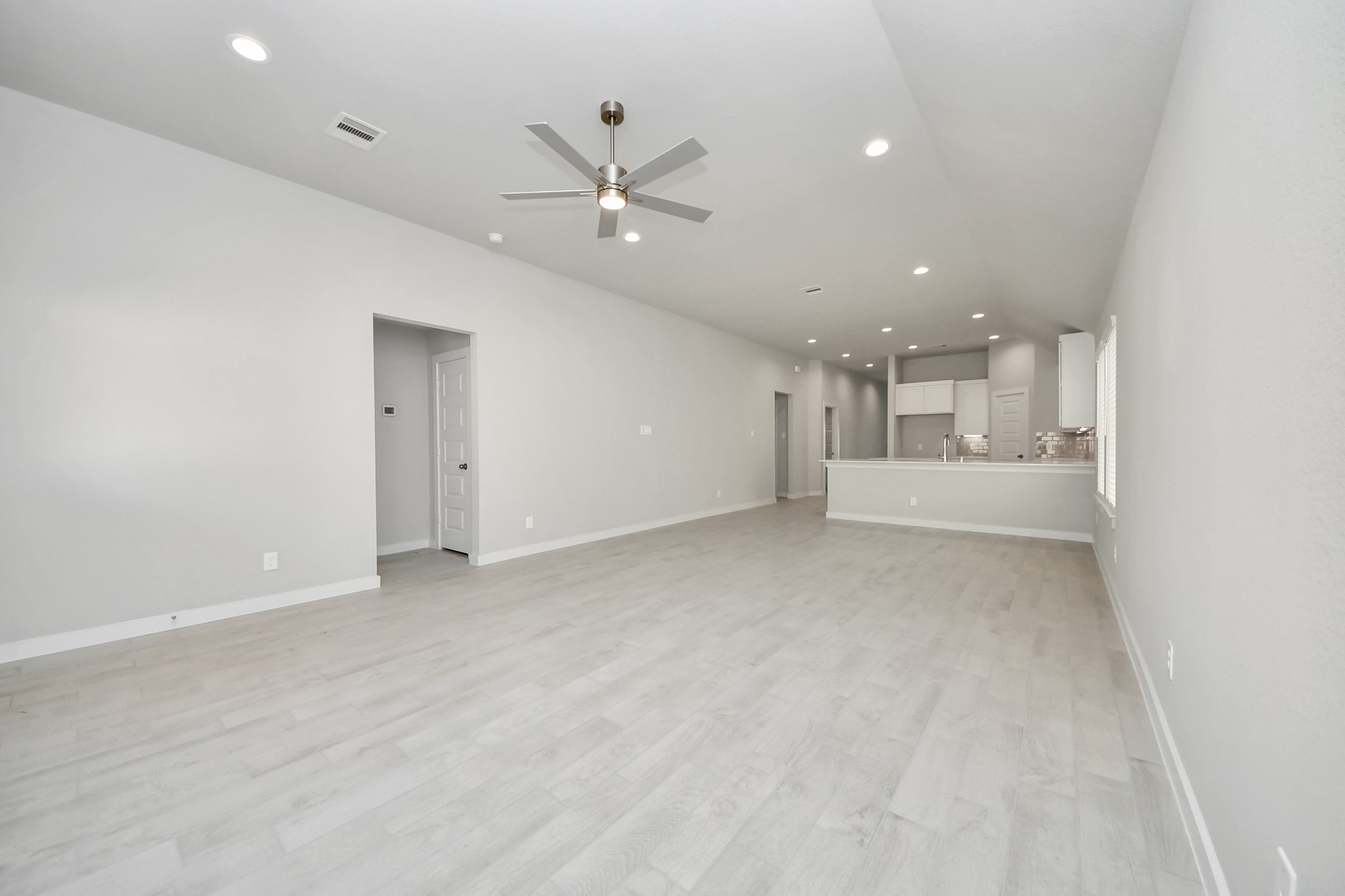 Welcome family and guests to your charming living room! With its high ceilings, recessed lighting, ceiling fan, custom paint, beautiful flooring, and large windows that let in abundant natural light, this room is perfect for gatherings. Sample photo of completed home with similar floor plan. Actual colors and selections may vary.
