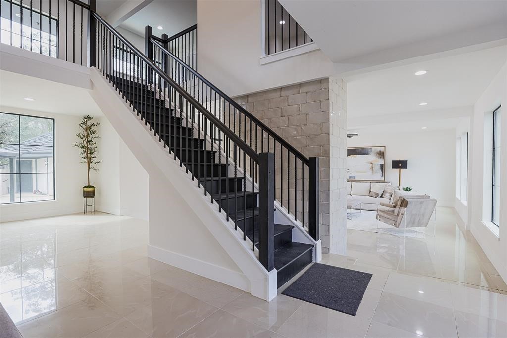 Alternate perspective of the grand entry showcasing a striking brick accent wall that leads into the open-concept living area. The blend of rich textures, from the tile flooring to the brick detail, creates a warm and inviting transition into the heart of the home.