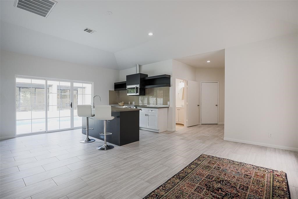 The guest house continues the homes sophisticated design, featuring sleek quartz countertops, a modern black, grey, and white color palette, and stylish tile flooring. The seamless transition in design ensures a cohesive and elegant living space that mirrors the main house's luxurious aesthetic.