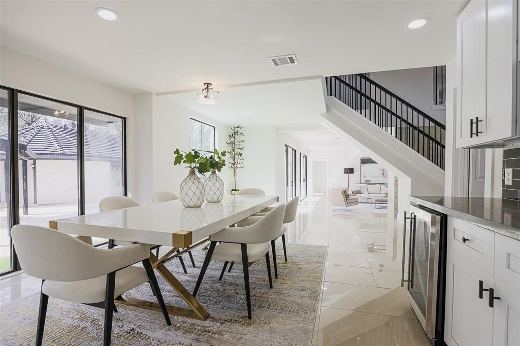 Spacious dining area with sleek tile flooring and a crisp white color palette, offering a bright and airy atmosphere. Large windows provide picturesque views of the pool, blending indoor dining with a serene outdoor backdrop. Spacious dining area with sleek tile flooring and a crisp white color palette, offering a bright and airy atmosphere. Large windows provide picturesque views of the pool, blending indoor dining with a serene outdoor backdrop.