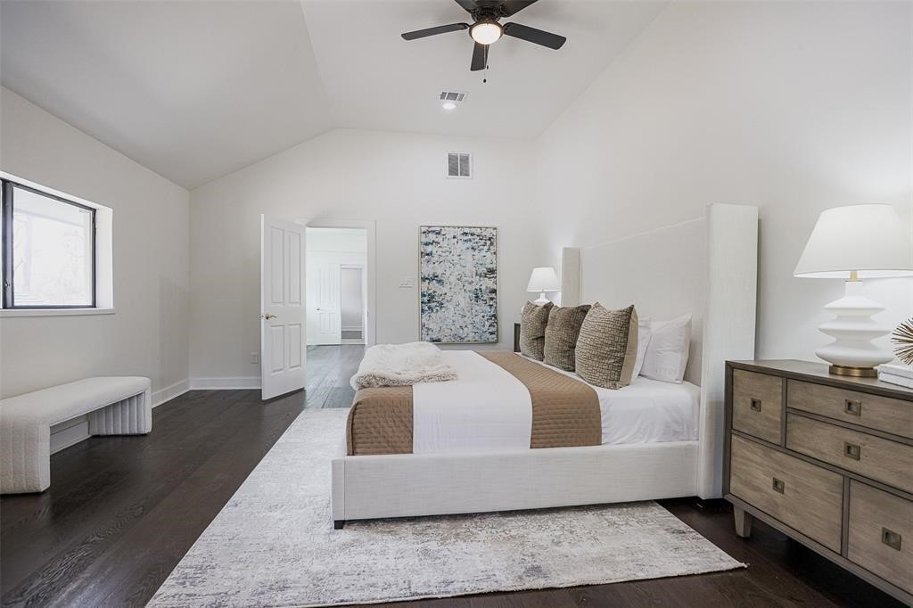 Luxurious primary suite featuring soaring ceilings and rich dark brown engineered wood flooring that adds warmth and sophistication. The suite includes an elegant ensuite bathroom and a spacious walk-in closet, offering both comfort and style in a private, tranquil retreat.
