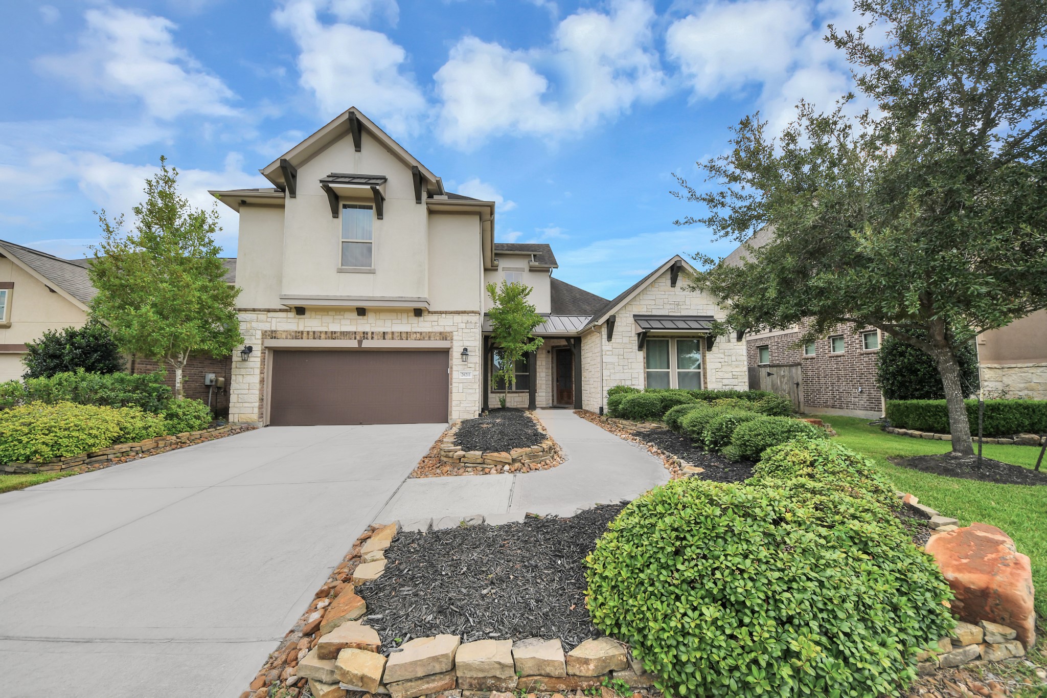 Impressive two-story home with stone accents, architectural details, and manicured landscaping. Impressive two-story home with stone accents, architectural details, and manicured landscaping.