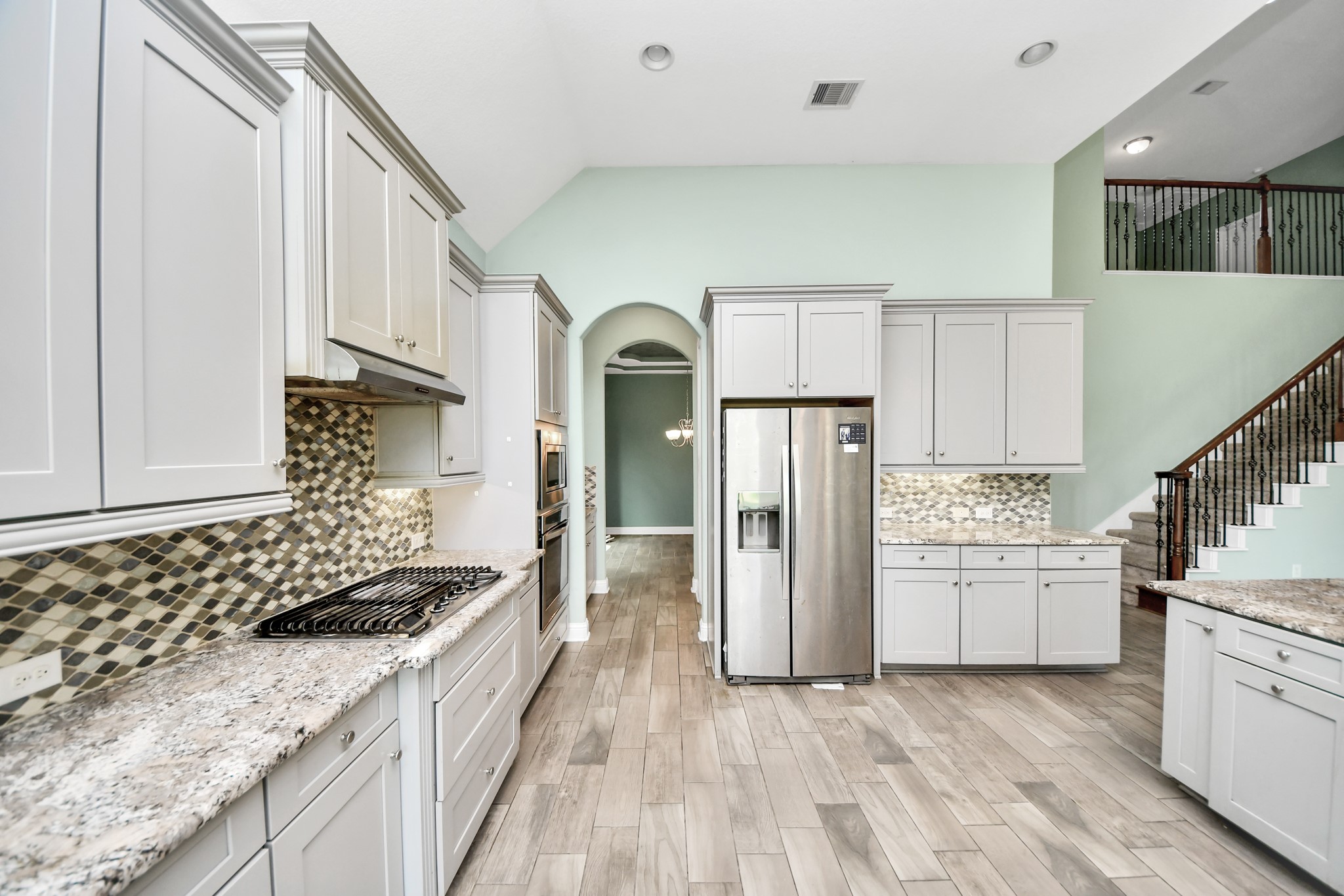 Expansive kitchen with large center island opens directly to the dramatic two-story living area, offering excellent flow for entertaining.