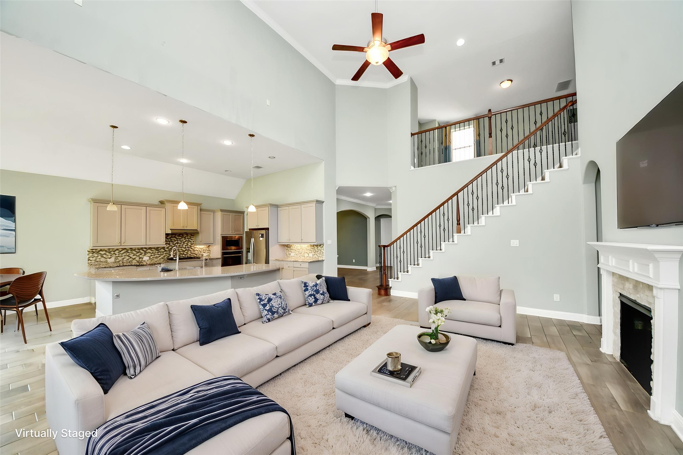 Virtually Staged Spacious family room featuring fireplace, architectural niches, staircase views, and flexible entertaining space. Virtually Staged Spacious family room featuring fireplace, architectural niches, staircase views, and flexible entertaining space.