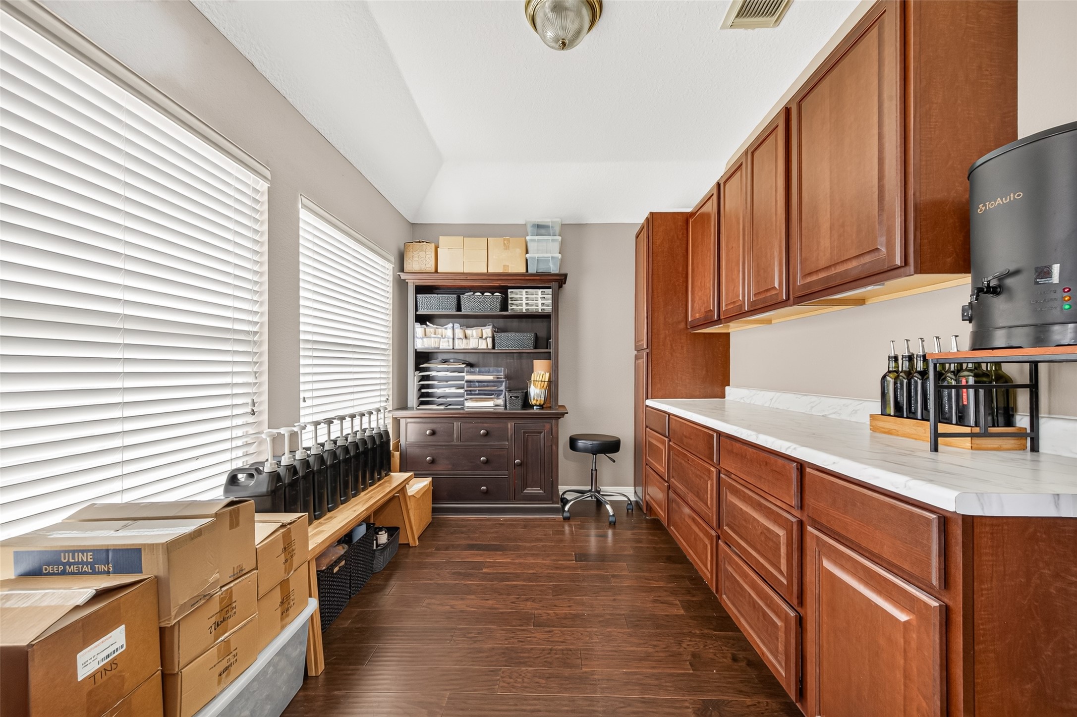 Bright and functional workspace featuring ample cabinetry, sleek countertops, and natural light perfect for organizing and or crafts.