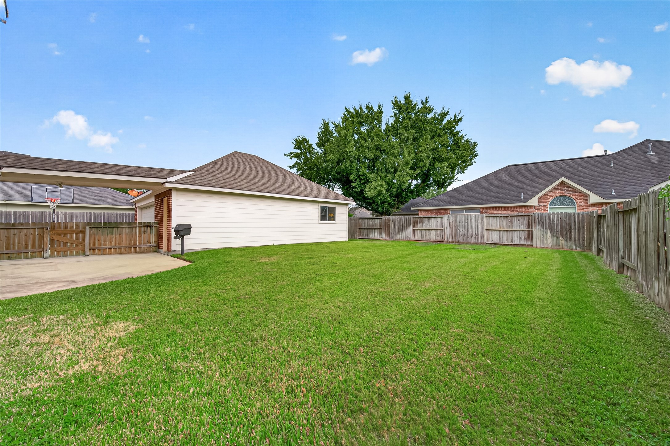 Backyard with lush green lawn perfect for outdoor activities, featuring a detached garage.