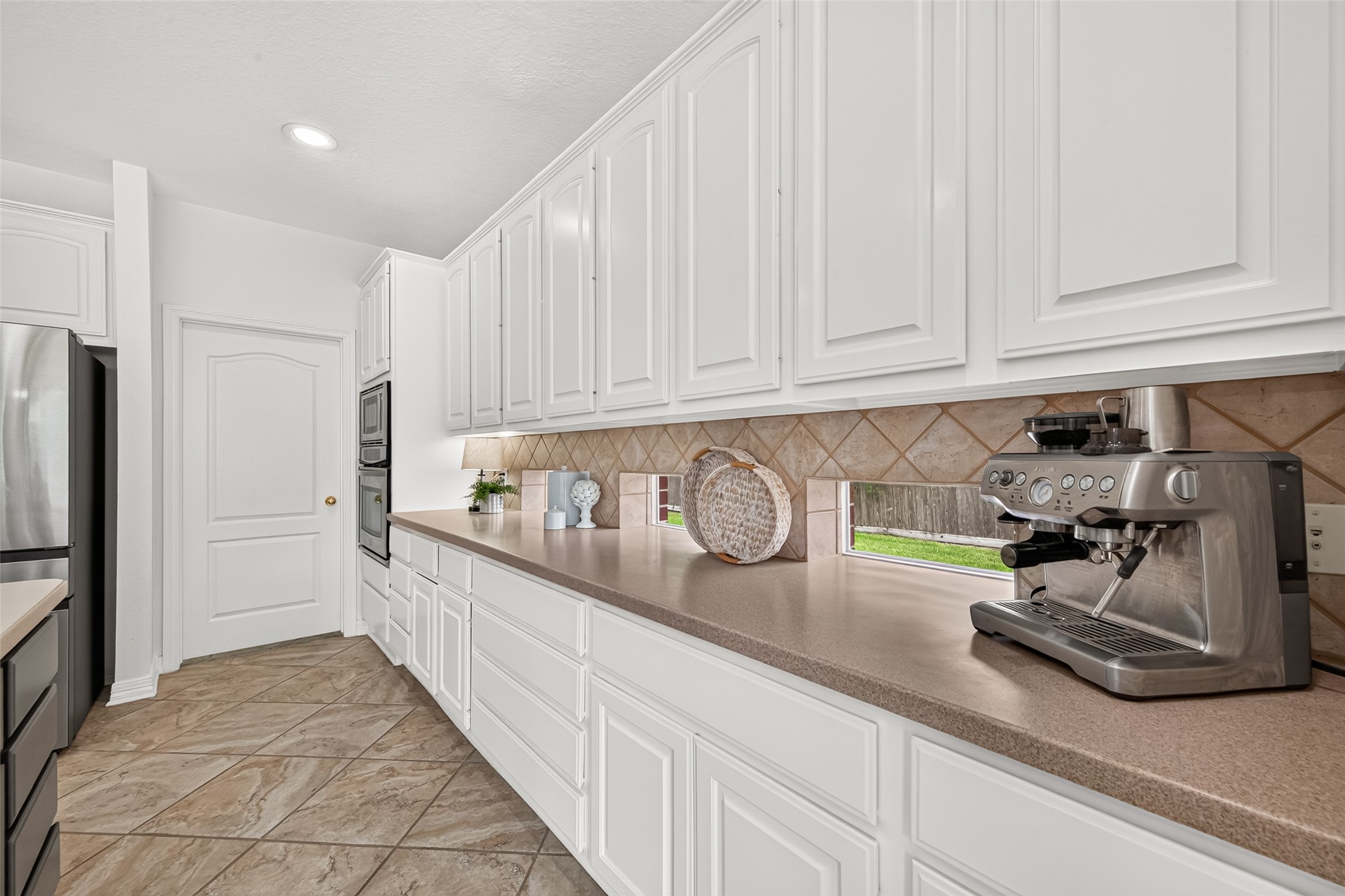Modern kitchen with sleek white cabinetry, stainless steel appliances, and ample counter space, perfect for culinary enthusiasts.