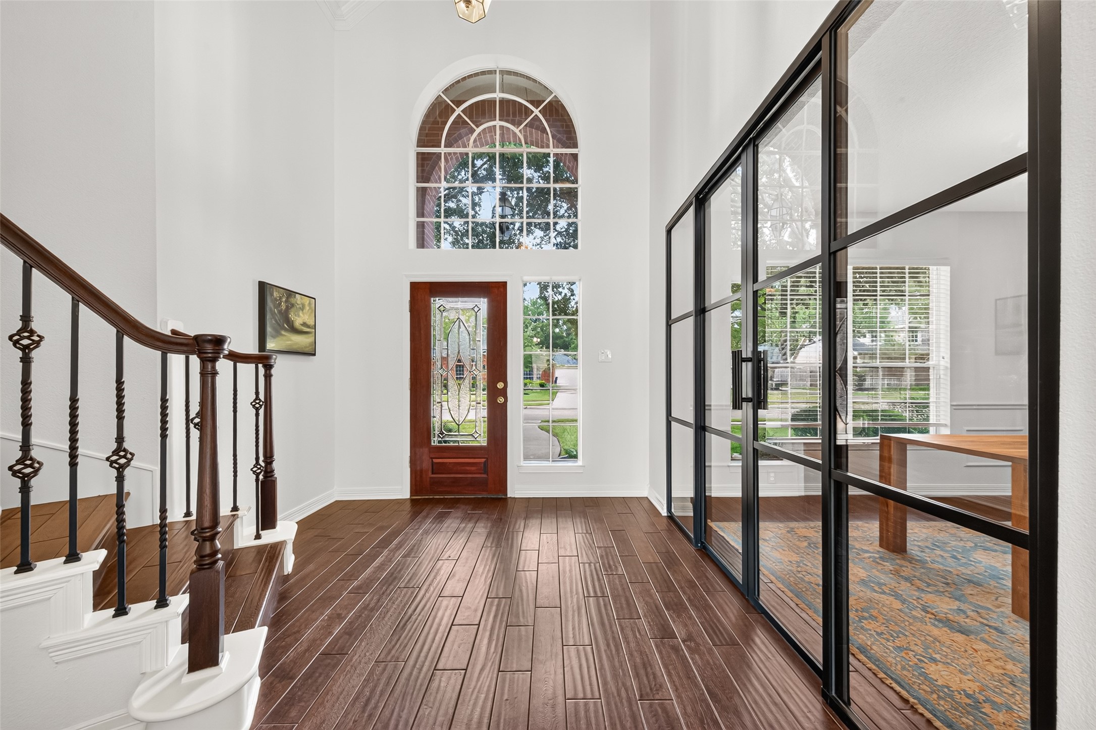 Stunning foyer with high ceilings, elegant staircase, and abundant natural light, complemented by a stylish glass-enclosed office. Stunning foyer with high ceilings, elegant staircase, and abundant natural light, complemented by a stylish glass-enclosed office.