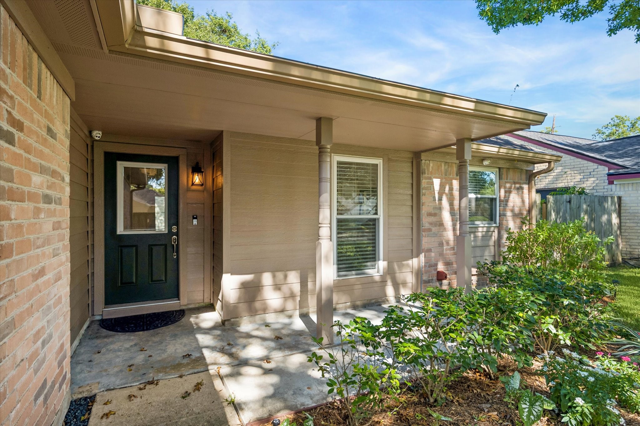 Step up to a welcoming entrance framed by attractive brickwork and thoughtfully maintained landscaping.