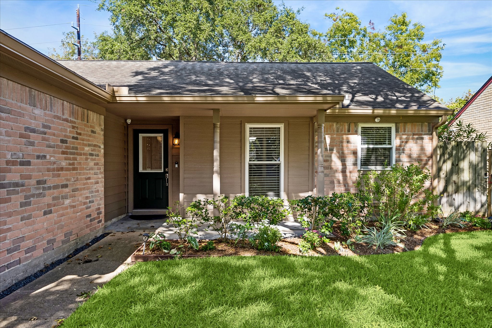Charming curb appeal awaits with a welcoming front entry, attached two-car garage, and beautiful mature trees.