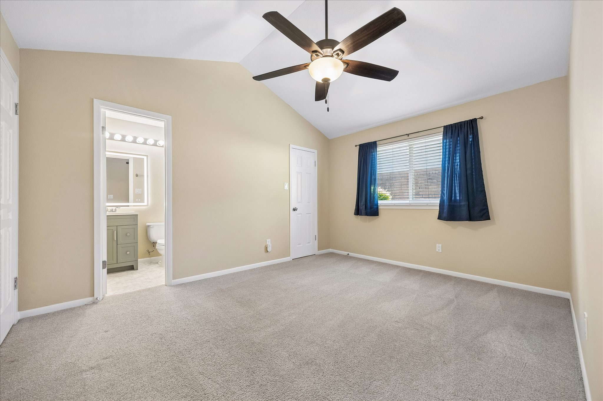 A bright and comfortable bedroom with an adjoining bathroom offers convenience and a welcoming place to unwind.