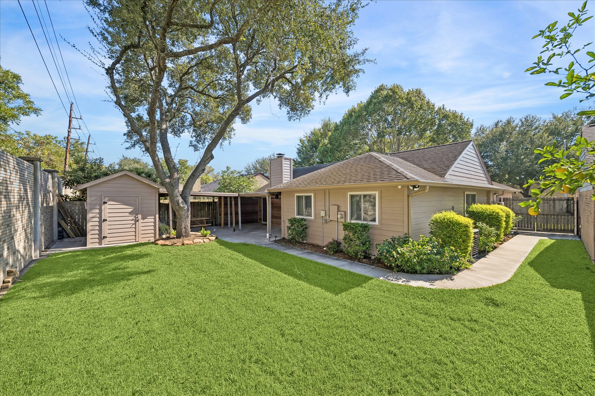 A generous backyard offers room to play, garden, or simply enjoy the outdoors, with mature trees and a covered patio to complete the setting.