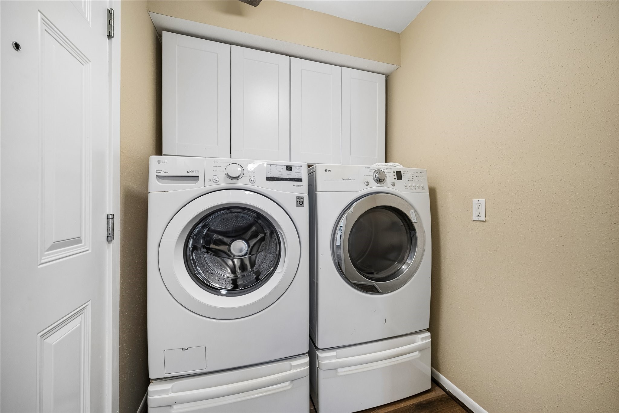 Laundry day is a little easier with a dedicated laundry room featuring a washer, dryer, and overhead storage.